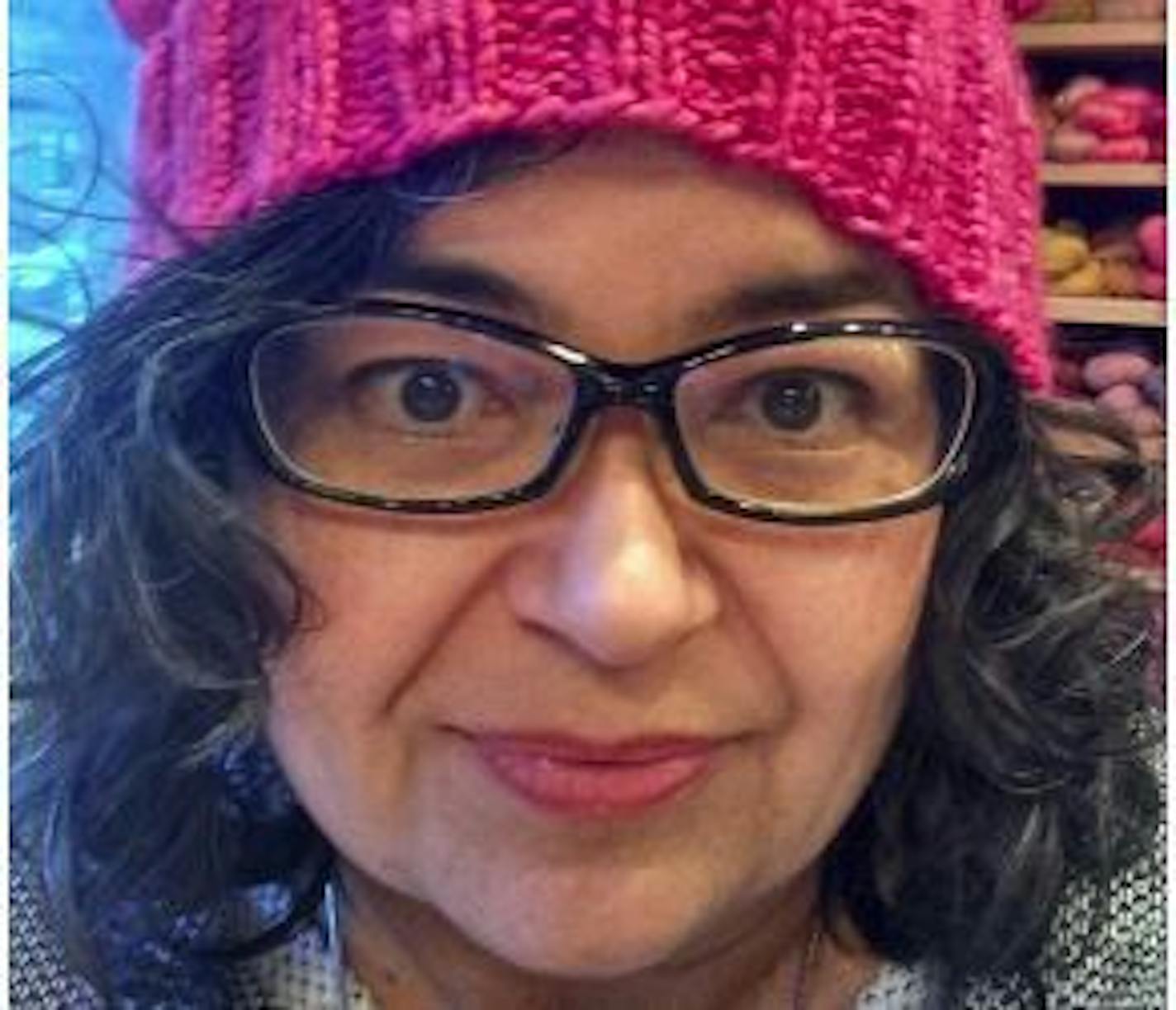 This January 2017 photo provided by Angie Paulson, shows Paulson, a knitter who works at the Yarnery shop in St. Paul, as she displays one of the "pussy" hats she made as part of a call to action answered by thousands of knitters to supply marchers at the Women's March in Washington, D.C., on Friday, Jan. 21, with warm headgear and a way to show their solidarity for women's rights.