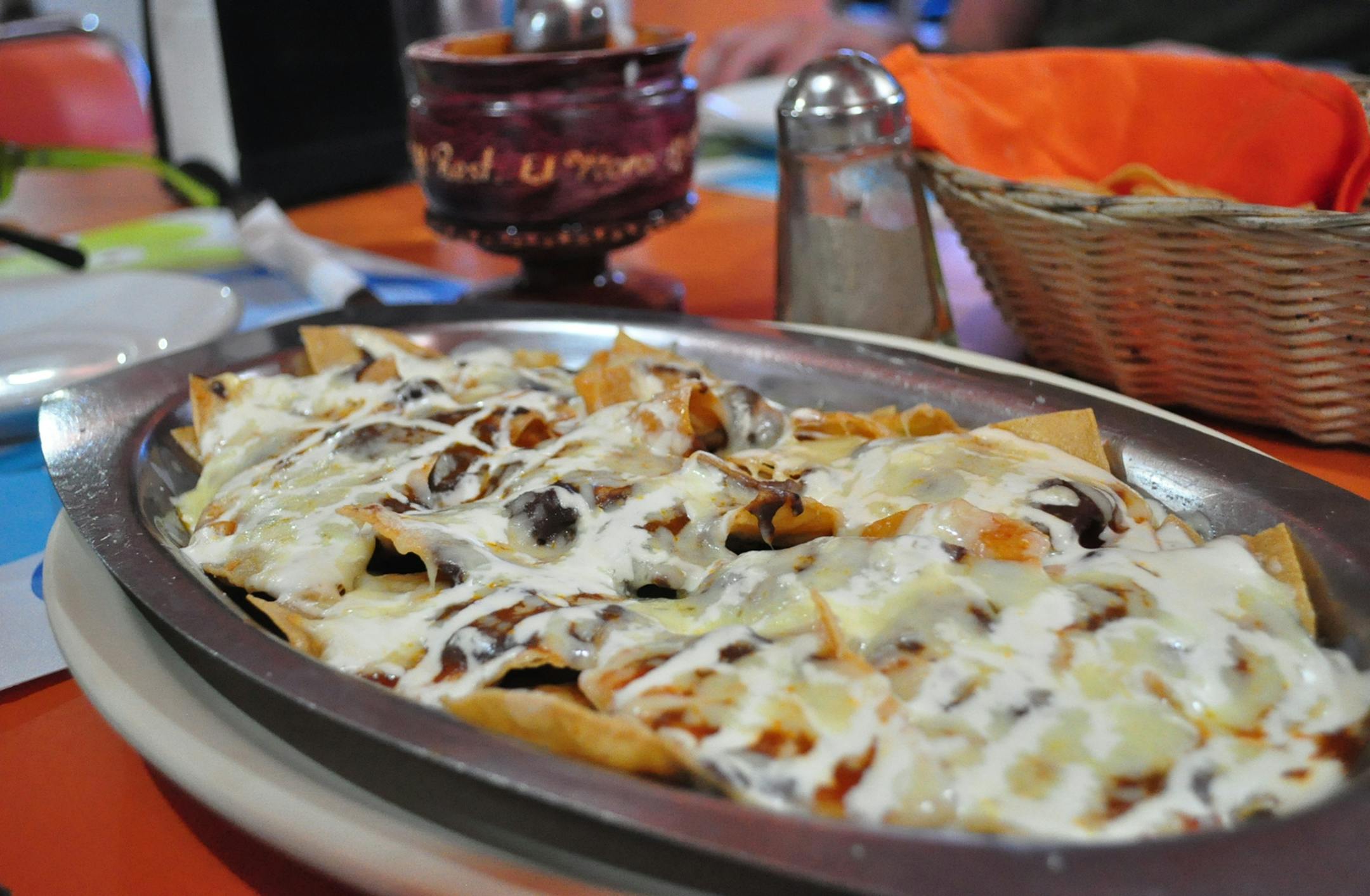 El Moroís nachos look nothing like the piled-high versions you find in the States; layers of beans, dark red sauce and queso blanco melt into the chips and disappear rapidly from the plates of appreciative diners. Photo for The Washington Post by Whitney Pipkin.