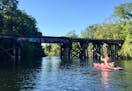 A kayaker made his way down the tranquil Boardman River through the heart of brewery-filled Traverse City.