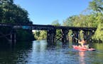 A kayaker made his way down the tranquil Boardman River through the heart of brewery-filled Traverse City.