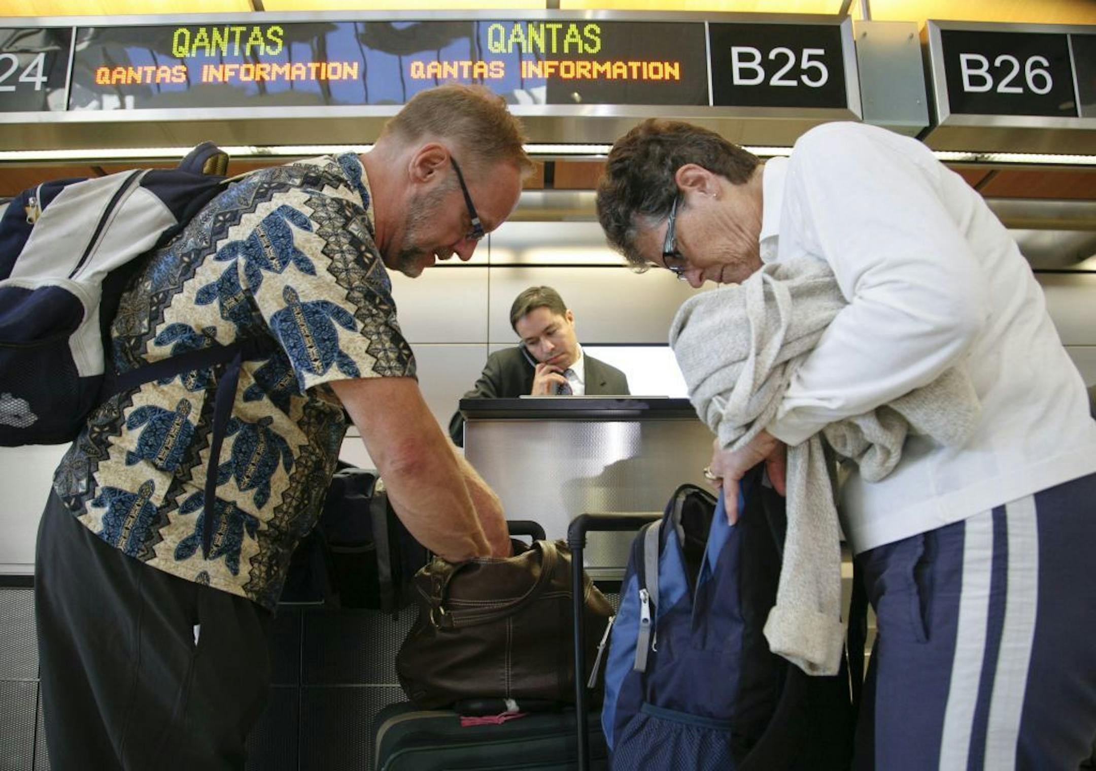 Authorities broke up a luggage theft ring at Los Angeles airport. In this 2011 file photo, Don, left, and Derry Dunsmore, of Mine Hill, N.J., go through their luggage at the Qantas counter at Los Angeles International Airport.