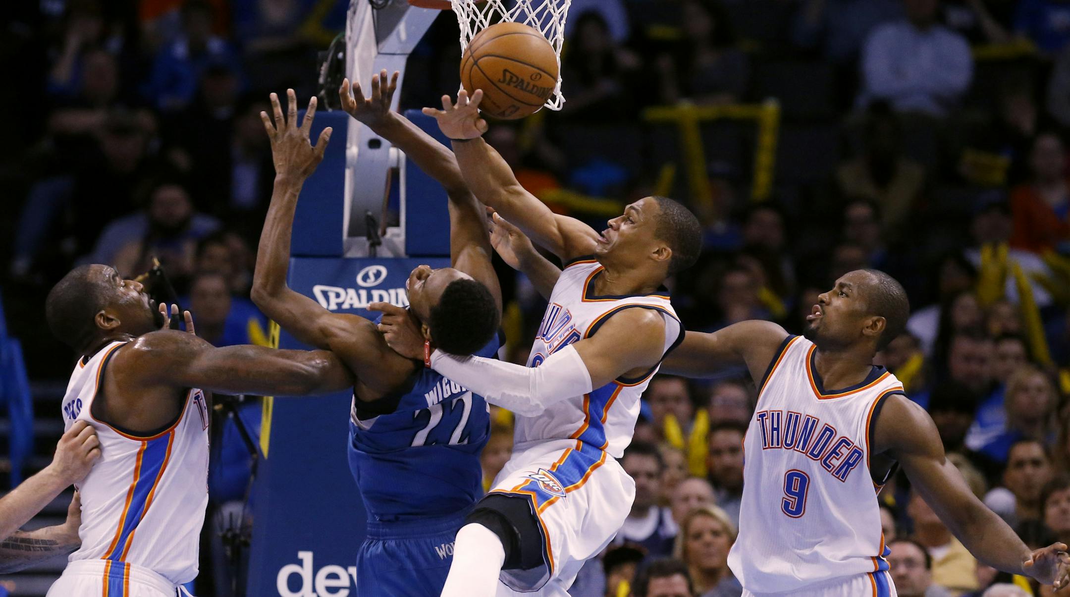 Minnesota Timberwolves forward Andrew Wiggins (22) loses the ball as he shoots while defended by Oklahoma City Thunder center Kendrick Perkins, left, Oklahoma City Thunder guard Russell Westbrook, center, and Oklahoma City Thunder forward Serge Ibaka (9) in the fourth quarter of an NBA basketball game in Oklahoma City, Monday, Jan. 26, 2015. Oklahoma City won 92-84. (AP Photo/Sue Ogrocki)