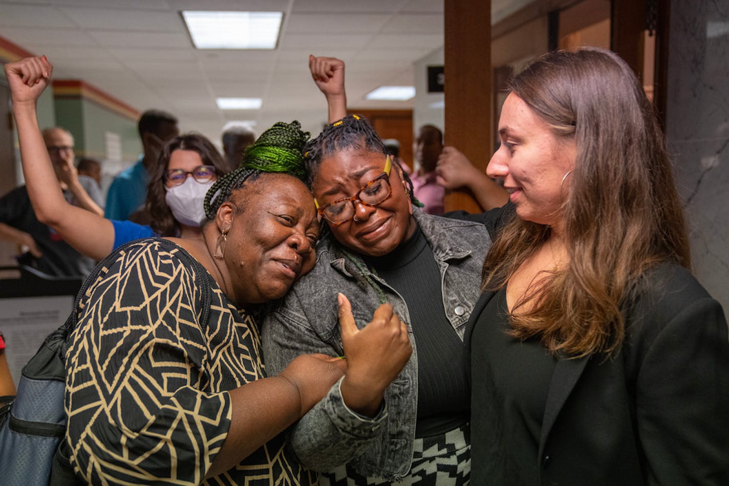 Marianna Brown, a driver for Uber and Lyft, embraces Minneapolis City Councilor Robin Wonsley while she celebrates with her aide, Celeste Robinson, after a 7-5 vote passed a new ordinance raising pay for ride share drivers Thursday, Aug. 17, 2023, at Minneapolis City Hall in Minneapolis, Minn. Wonsley was a co-author of the ordinance. ]