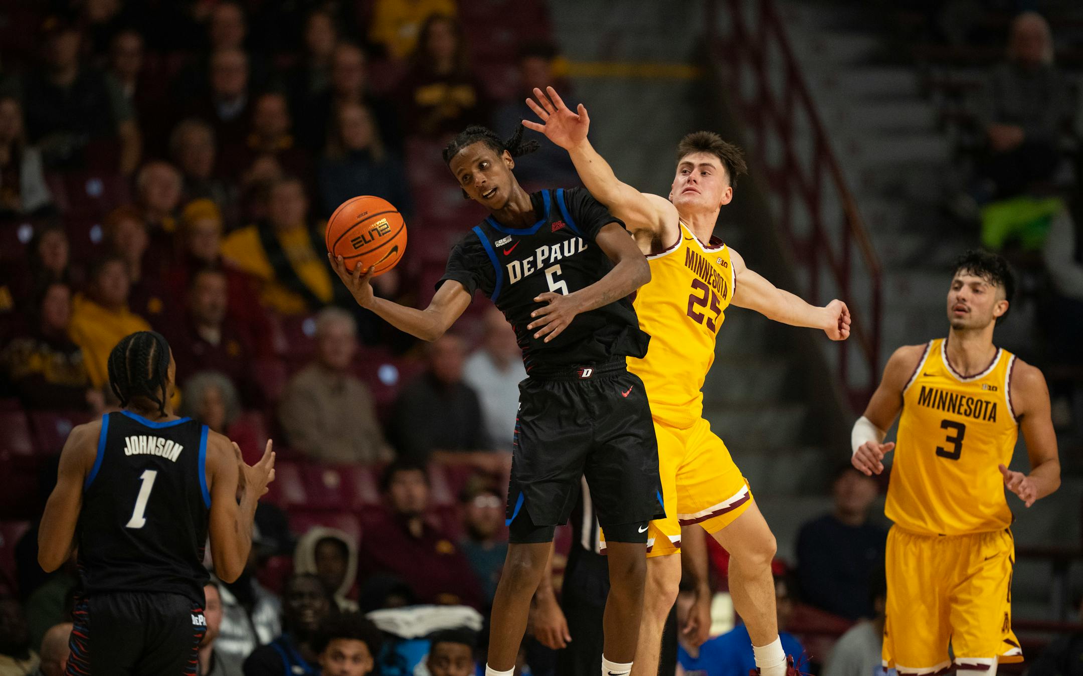 DePaul Blue Demons guard Philmon Gebrewhit (5) caught a pass while defended by Minnesota Gophers guard Will Ramberg (25) in the second half.