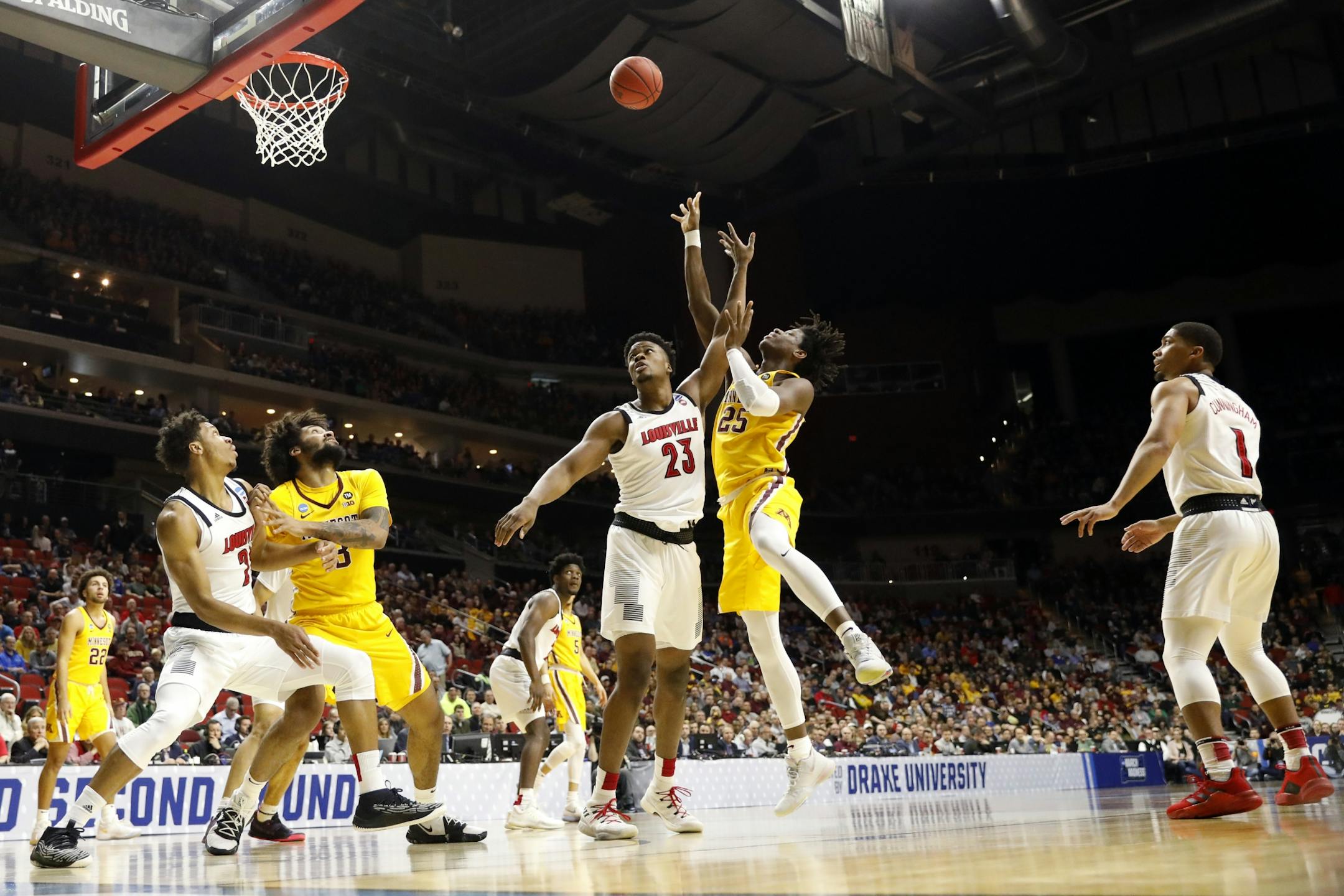 Minnesota center Daniel Oturu (25) shoots over Louisville center Steven Enoch (23) during a first round men's college basketball game in the NCAA Tournament, Thursday, March 21, 2019, in Des Moines, Iowa.
