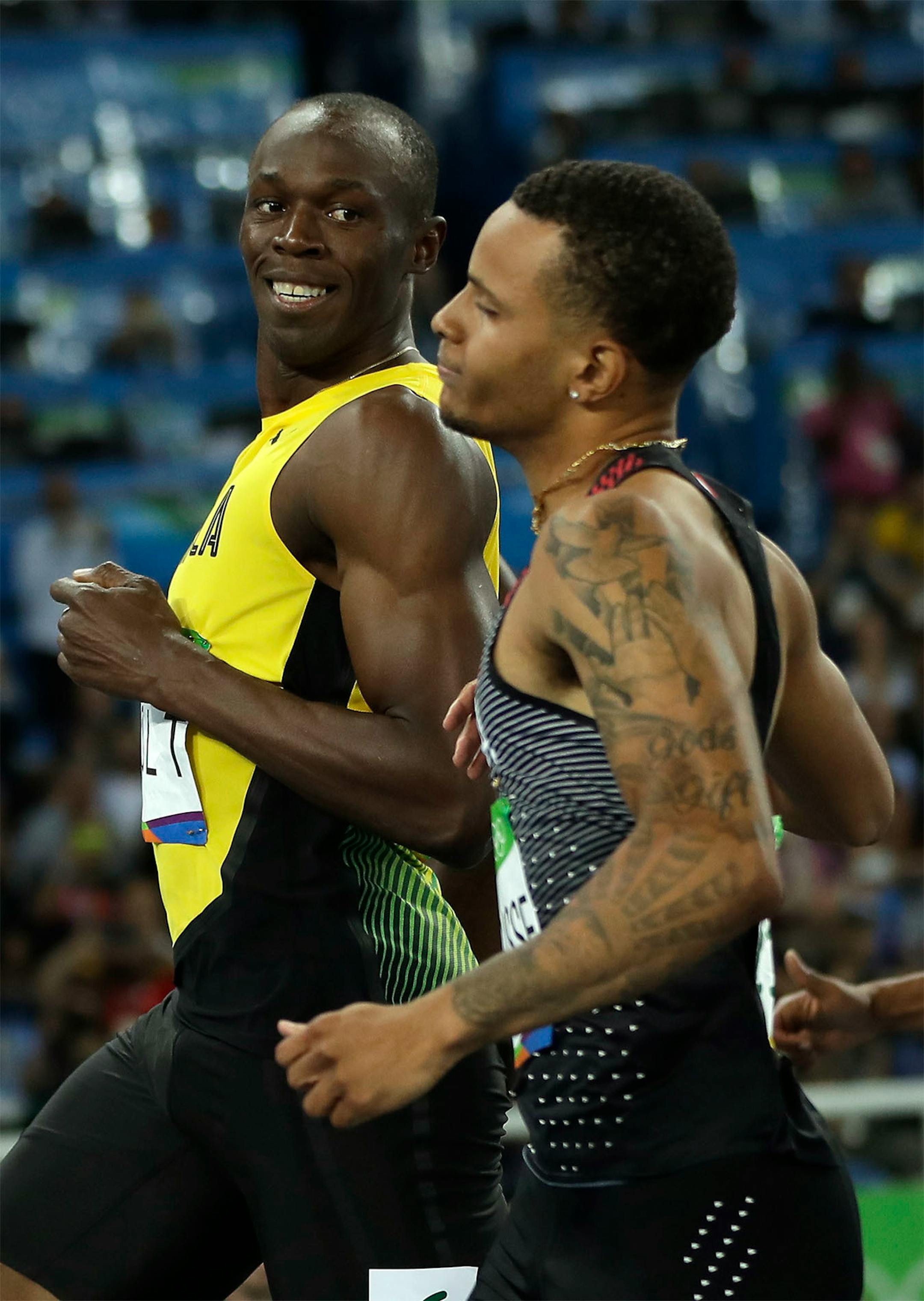 Jamaica's Usain Bolt, left, looks to Canada's Andre De Grasse after crossing the line during a men's 100-meter semifinal during the athletics competitions in the Olympic stadium of the 2016 Summer Olympics in Rio de Janeiro, Brazil, Sunday, Aug. 14, 2016.