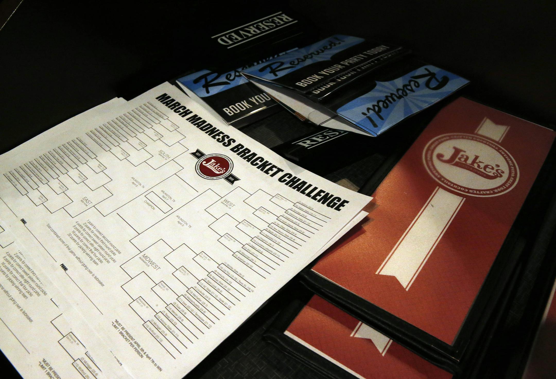 A stack of blank NCAA brackets sits with menus, available to patrons at Jake's sports bar, in Denver, Monday March 17, 2014. Warren Buffett has promised a billion dollars for a perfect NCAA bracket, the chances of which are astronomically small. The NCAA March Madness tournament is to begin Tuesday. (AP Photo/Brennan Linsley)