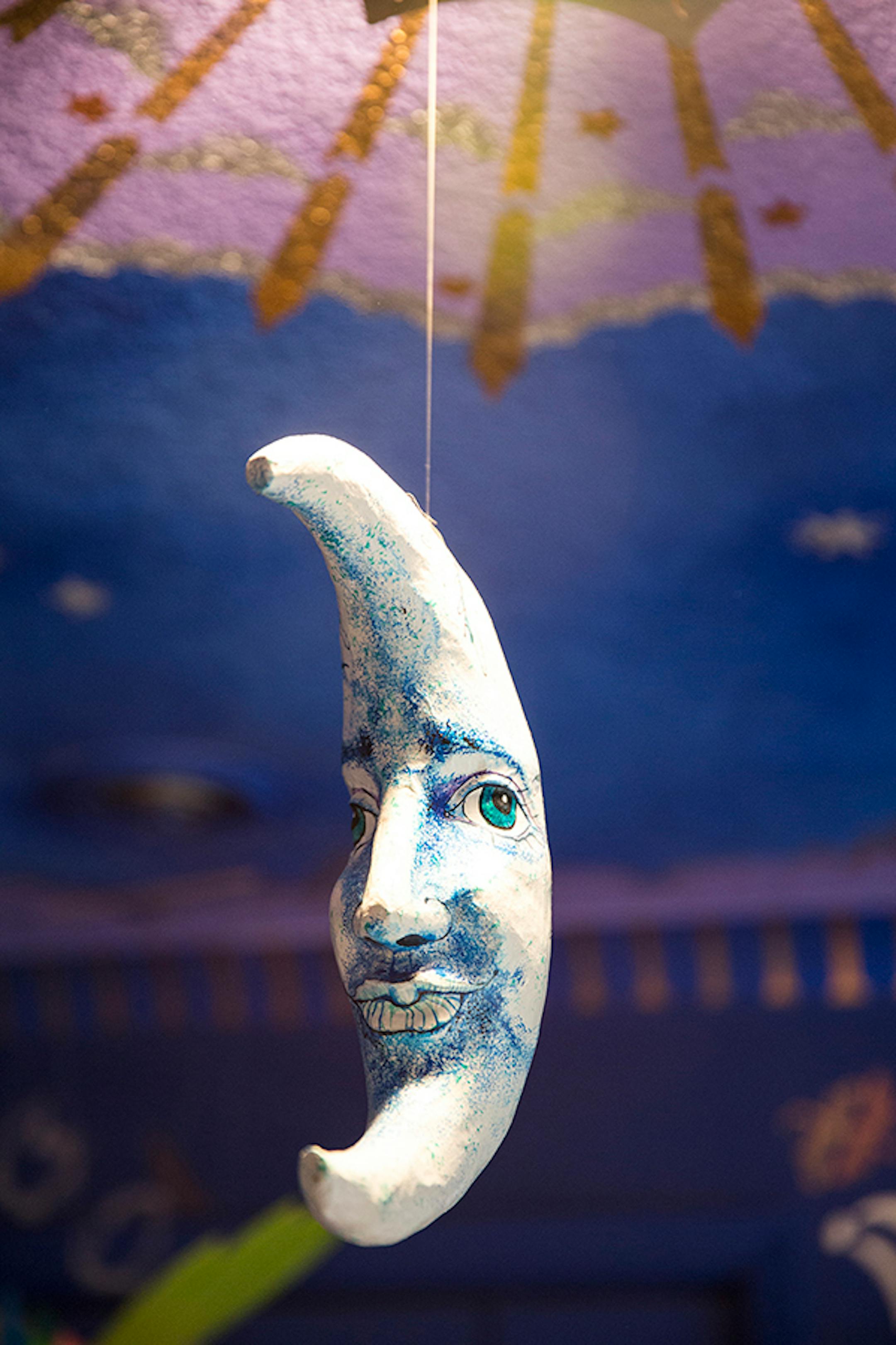 This moon is suspended from the painted ceiling medallion.