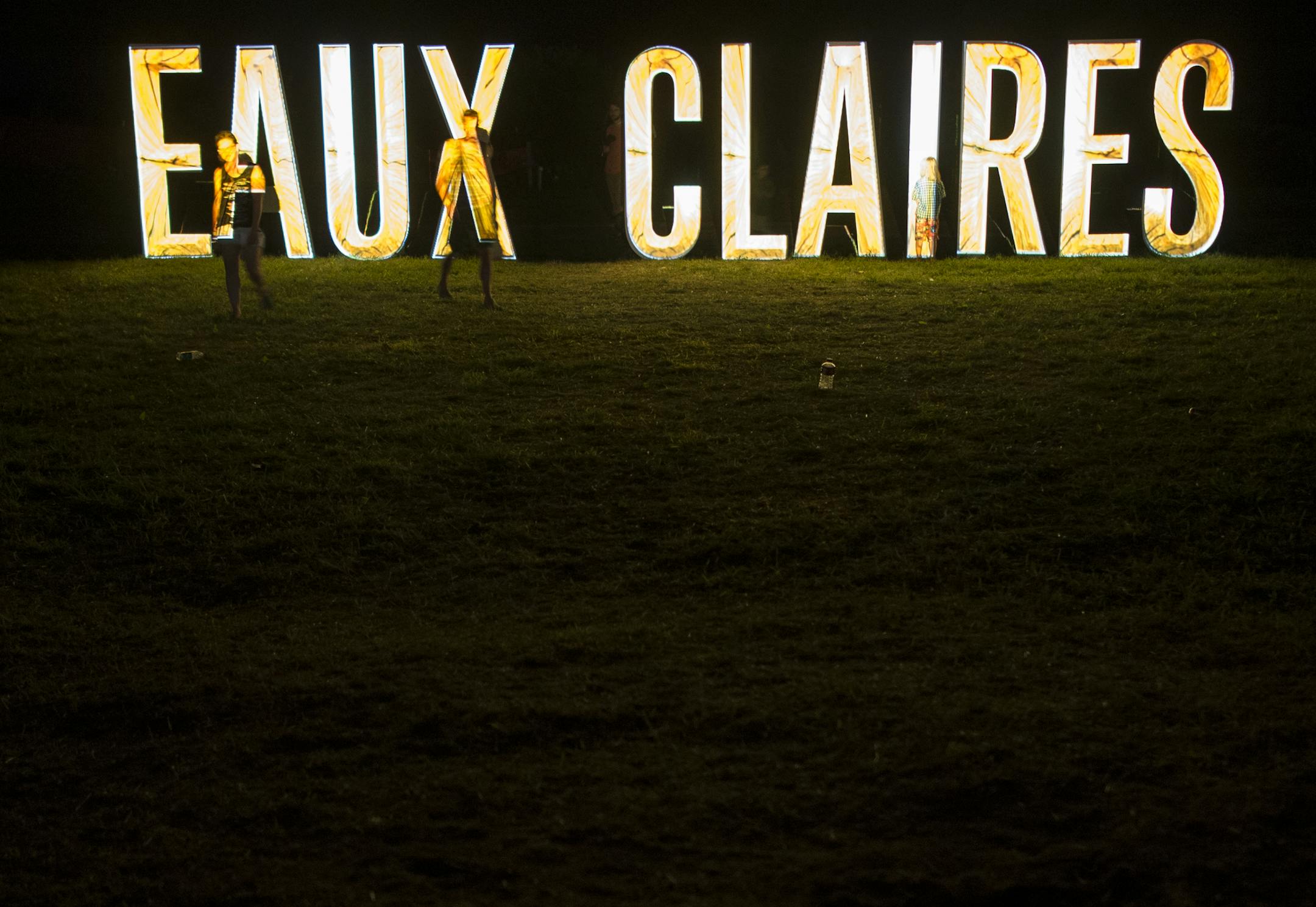 Festival goers walked along the illuminated Eaux Claires sign Saturday night during Bon Iver's set. ] Aaron Lavinsky • aaron.lavinsky@startribune.com The Eaux Claires Music & Art Festival was photographed Saturday, July 18, 2015 in Eau Claire, WI.