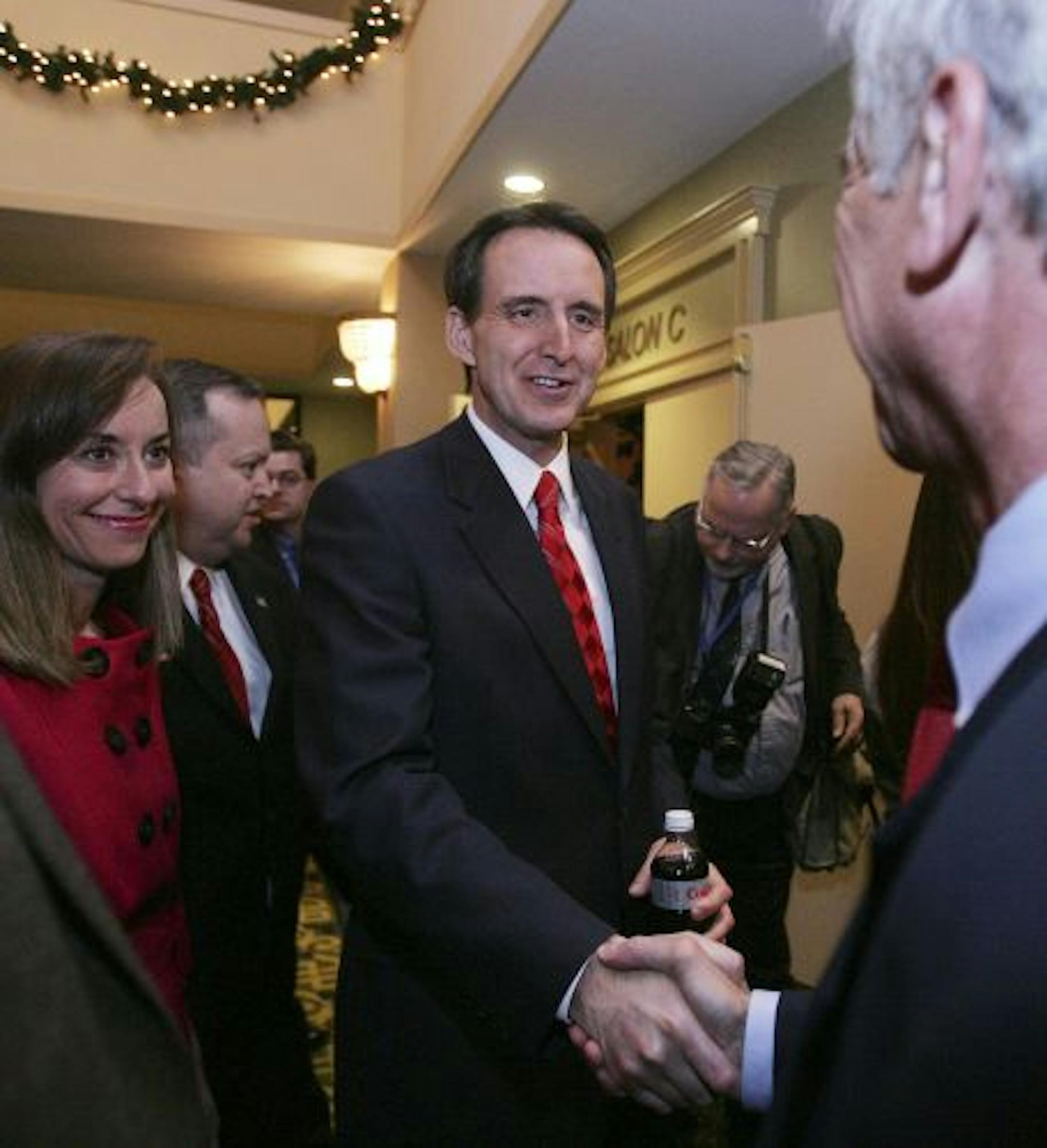 Gov. Tim Pawlenty, R-Minn., shakes hands as he greets New Hampshire Republicans with his wife Mary during a GOP fund-raiser for state senate seats in Concord, N.H., Wednesday, Dec. 16, 2009.