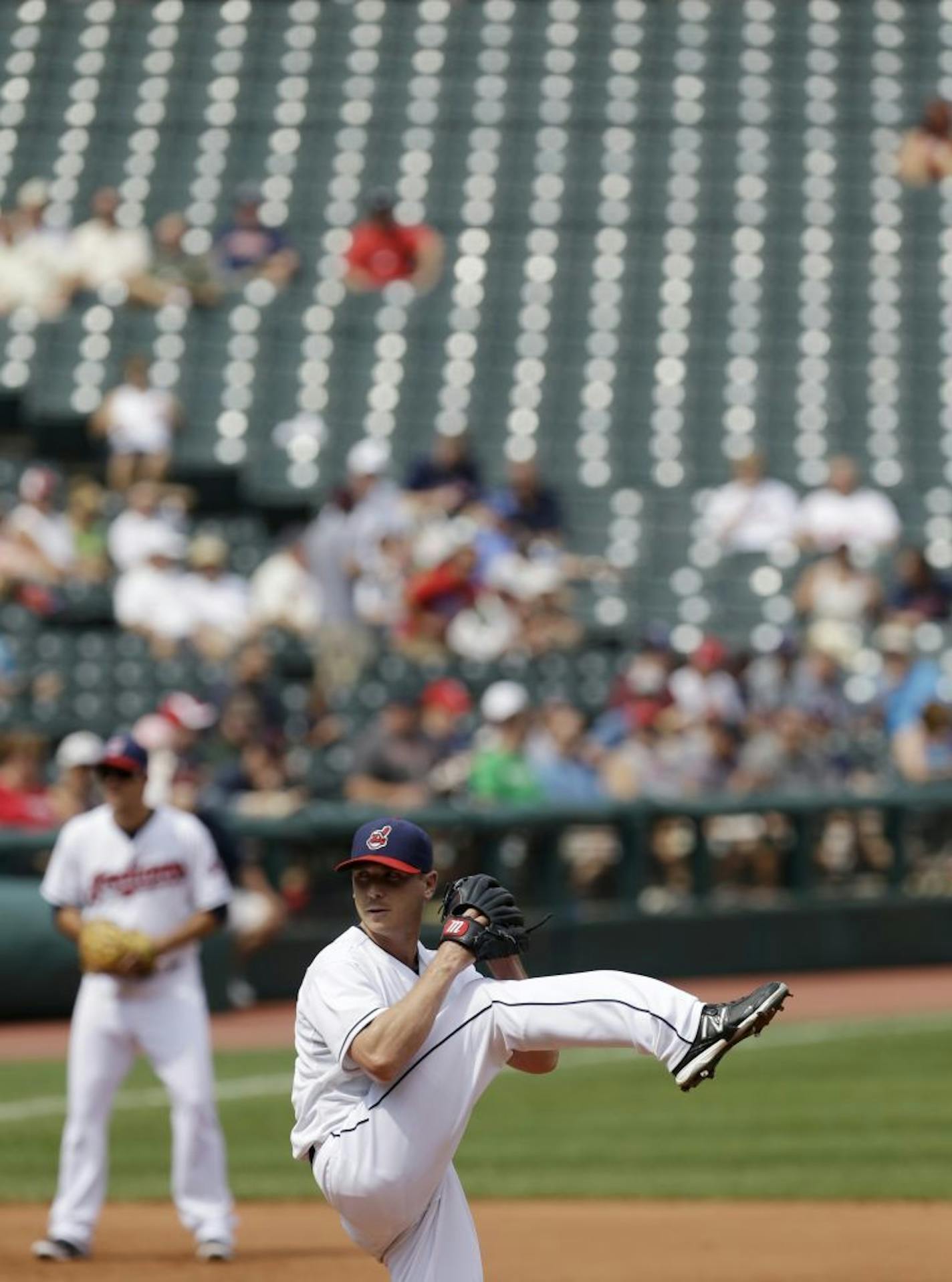 ADVANCE FOR WEEKEND EDITIONS, SEPT. 14-15 - In this photo taken Wednesday, Sept. 11, 2013, Cleveland Indians starting pitcher Scott Kazmir winds up to throw in the fourth inning of a baseball game against the Kansas City Royals in Cleveland. The standings say the Indians are in the thick of a playoff race. You'd never know it looking in the stands at Progressive Field. The sight of empty seats has been shocking to a team looking to play in October.