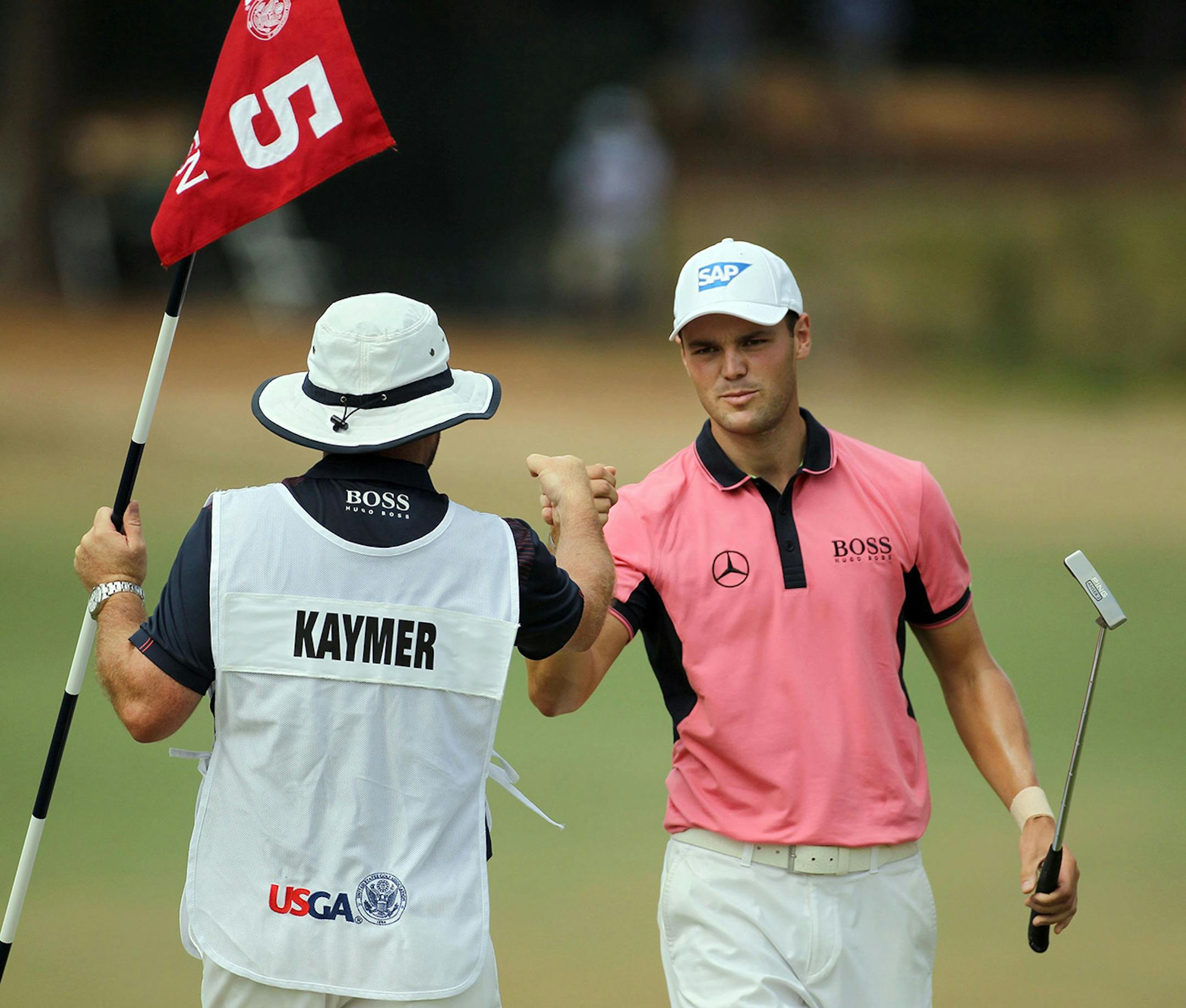 Golfer Martin Kaymer of Dusseldorf, Germany, right, fist bumps his caddy, Craig Connolly, after an eagle on the fifth hole during the third round of the 2014 U.S. Open at Pinehurst No. 2 in Pinehurst, N.C., Saturday, June 14, 2014.