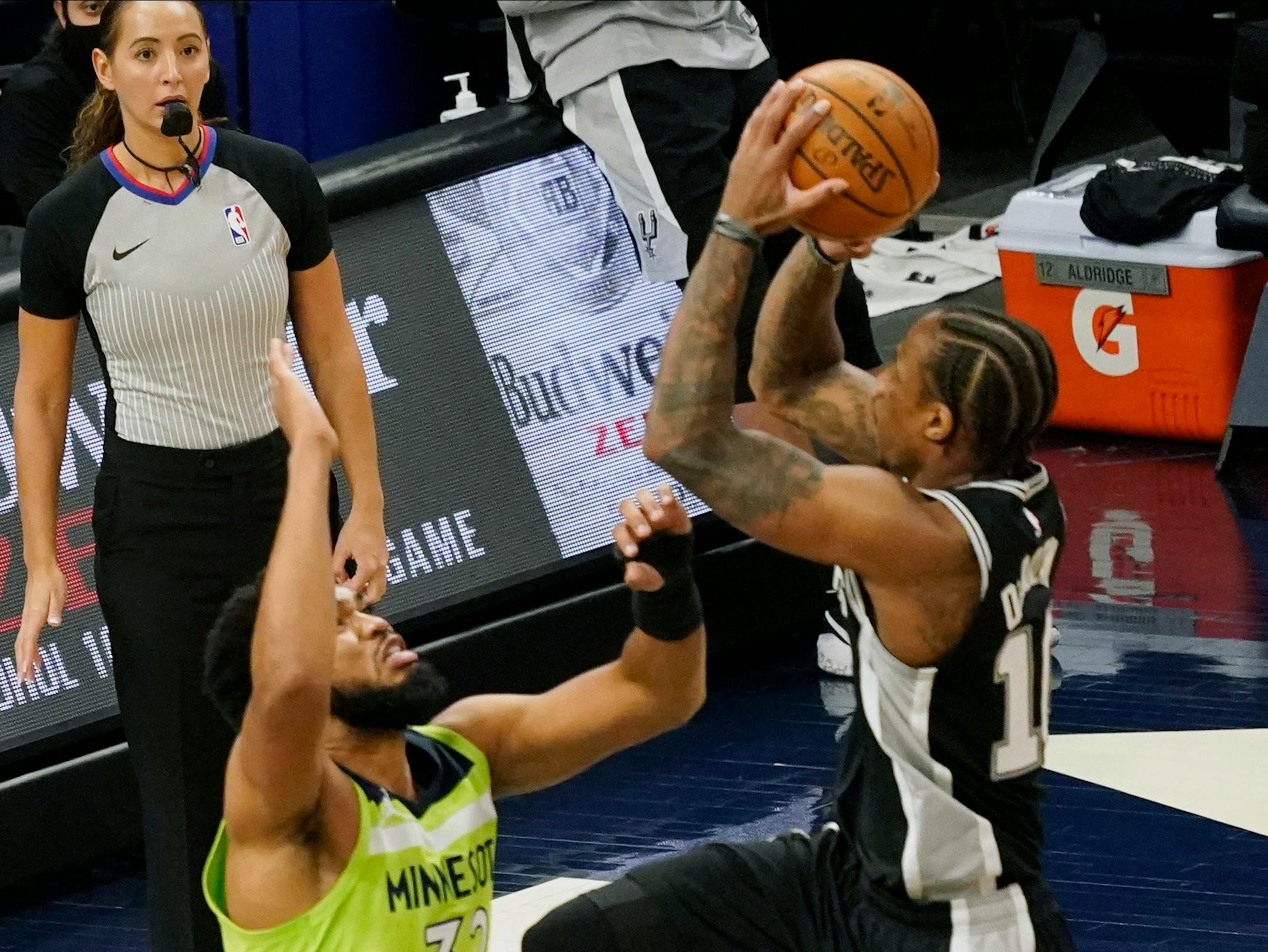 San Antonio Spurs' DeMar DeRozan, right, shoots over Minnesota Timberwolves' Karl-Anthony Towns in the second half of an NBA basketball game Saturday, Jan. 9, 2021, in Minneapolis. (AP Photo/Jim Mone)