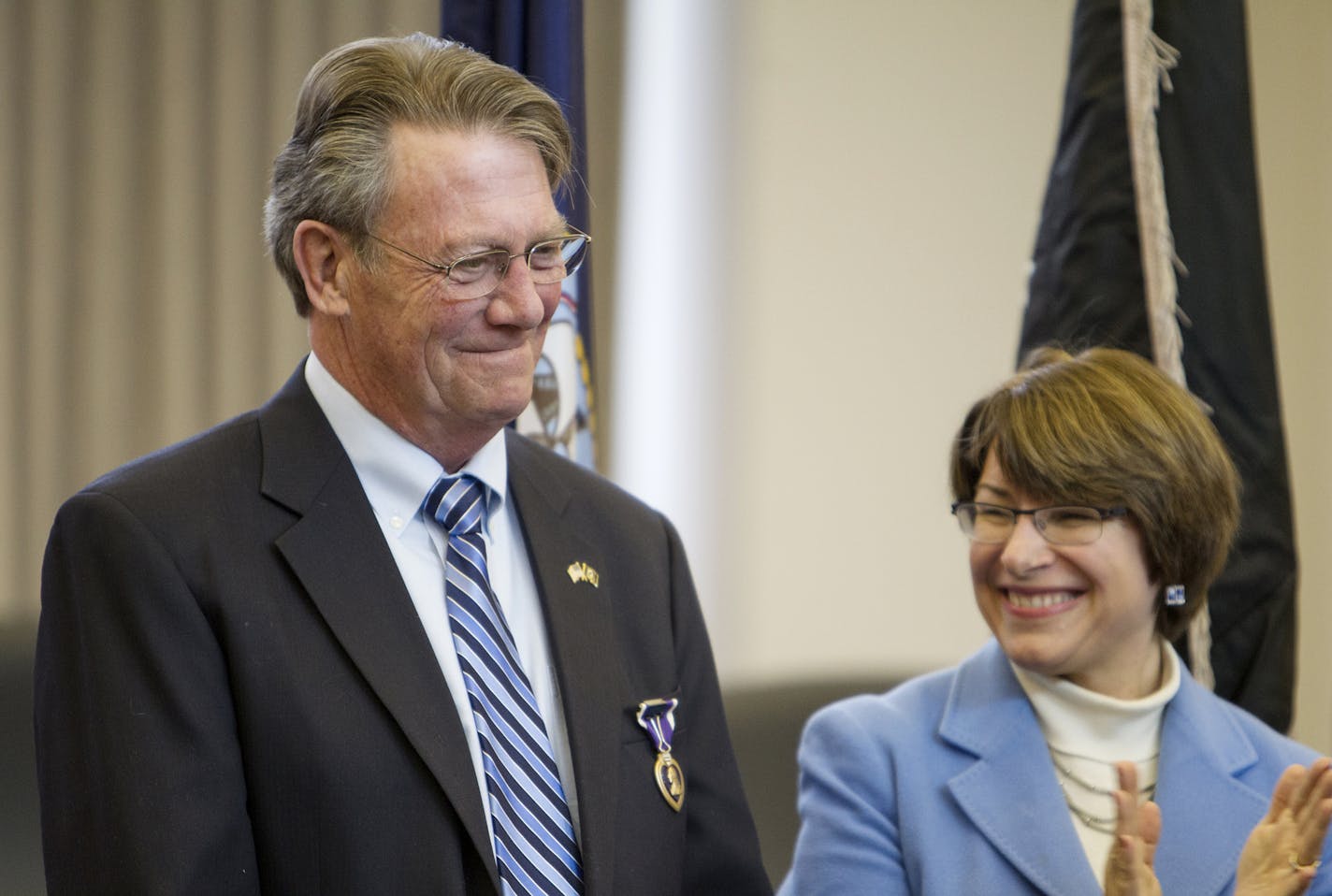 U.S. Sen. Amy Klobuchar, right, applauded with the crowd after awarding the Purple Heart to Vietnam veteran Fred Jenness Monday at Golden Valley City Hall.