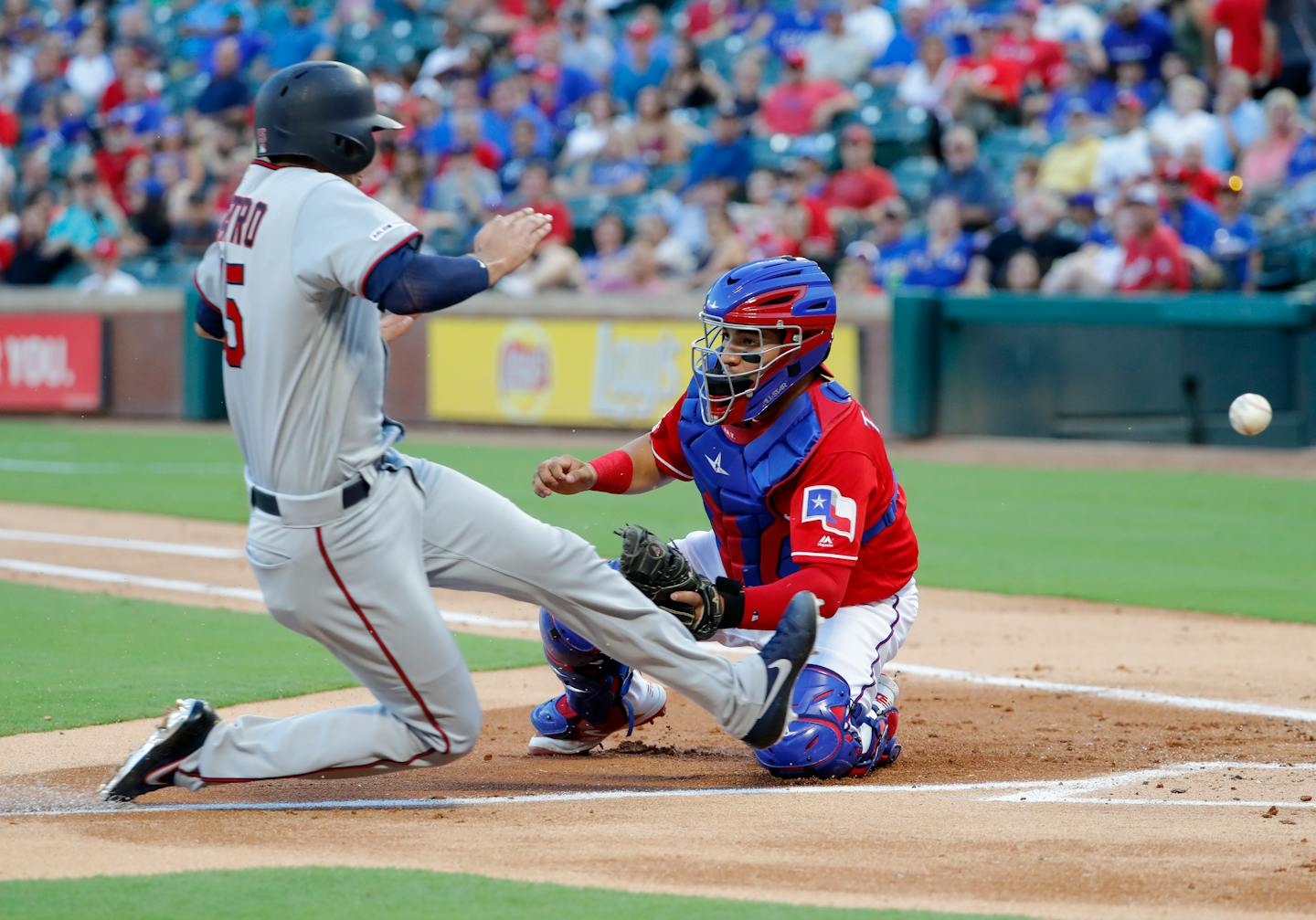 Minnesota Twins' Jason Castro scores on a fielders choice by Max Kepler as Texas Rangers catcher Jose Trevino is unable to field the throw to the bag in the second inning of a baseball game in Arlington, Texas, Thursday, Aug. 15, 2019. Jake Cave also scored on the play with a throwing error charged to the Rangers' Elvis Andrus. (AP Photo/Tony Gutierrez)