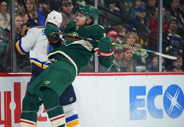 Minnesota Wild left wing Marcus Foligno (17) checked St. Louis Blues defenseman Marco Scandella (6) into the boards in the corner in the first period.