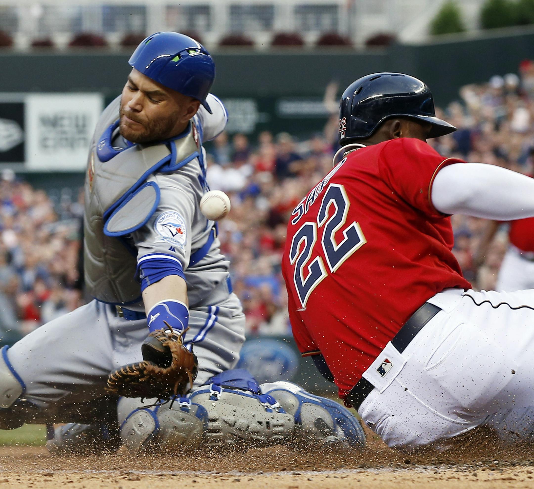Toronto Blue Jays catcher Russell Martin, left, can't pull in the throw to the plate as Minnesota Twins' Miguel Sano scores on an RBI double by Robbie Grossman off Blue Jays pitcher Aaron Sanchez in the second inning of a baseball game Friday, May 20, 2016, in Minneapolis. (AP Photo/Jim Mone)