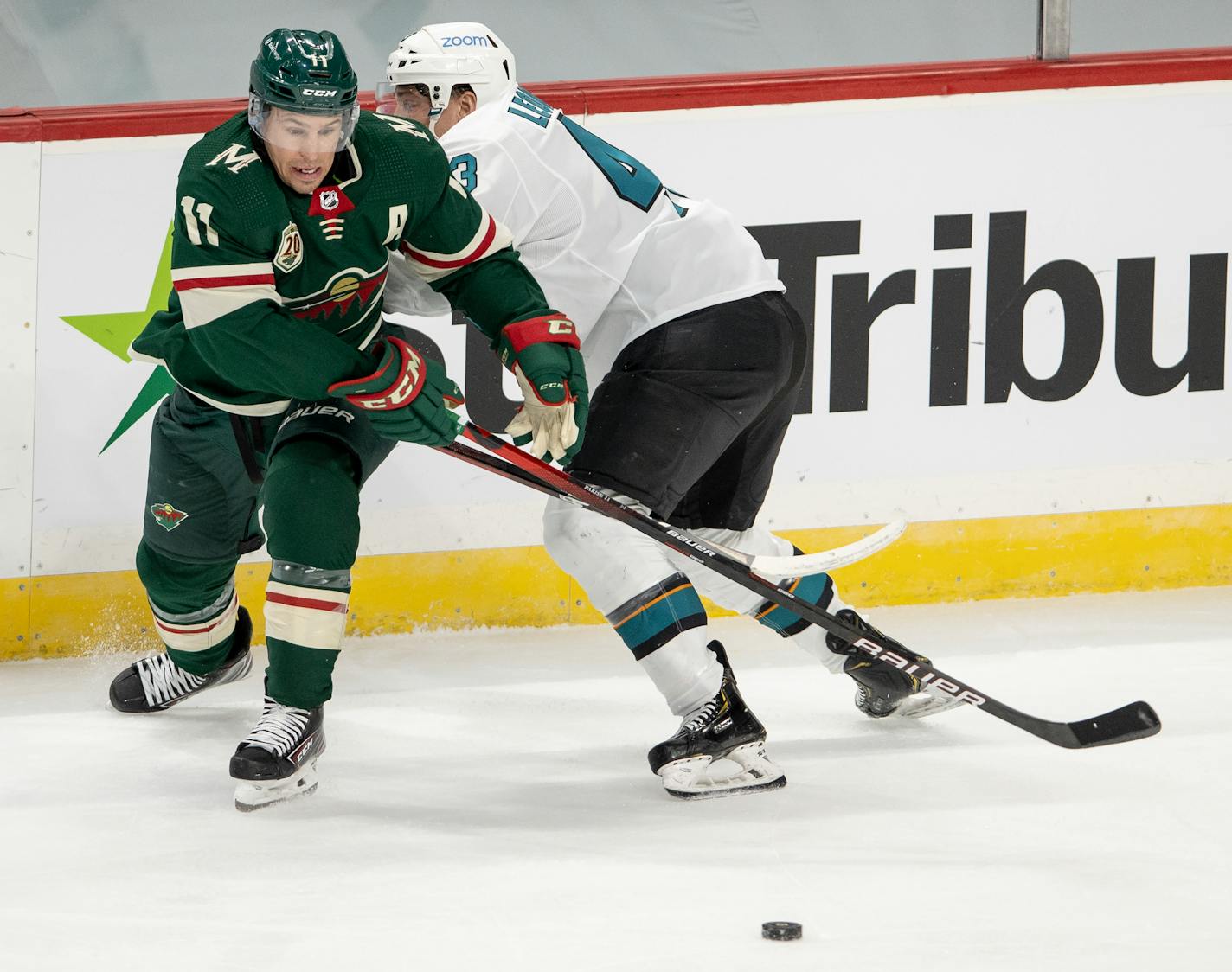 Wild winger Zach Parise and the Sharks' John Leonard fought for the puck in the second period. Parise scored the game's first goal, but the Sharks prevailed 5-3 at Xcel Energy Center on Sunday.