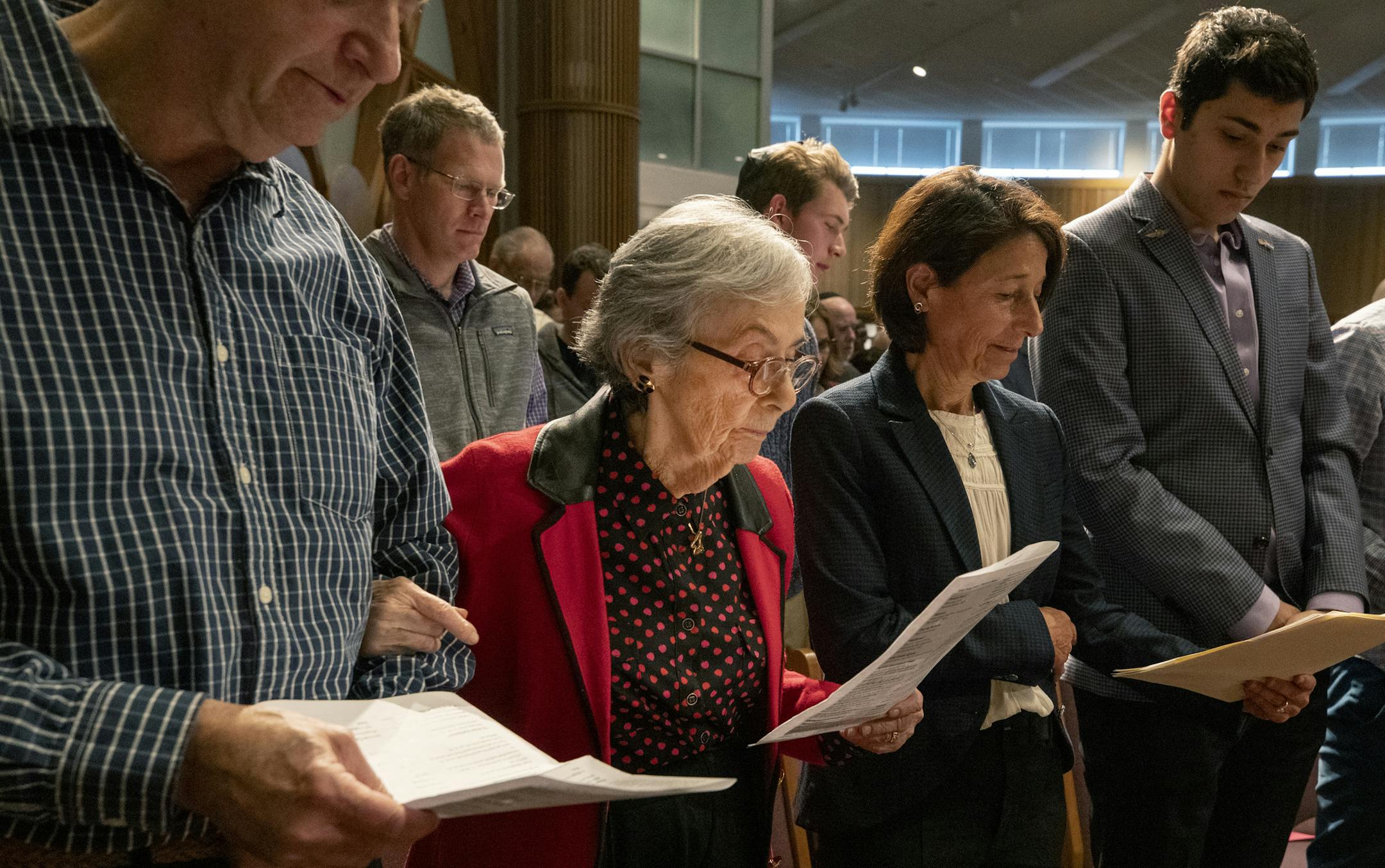 Holocaust survivor Judy Baron, 91, (in red) stood with her children Gary Baron and Susan Miller during a Holocaust Commemoration at Bet Shalom Congregation. ] CARLOS GONZALEZ • cgonzalez@startribune.com – Minneapolis, MN – May 2, 2019, The annual Holocaust Commemoration will be held at Bet Shalom Congregation