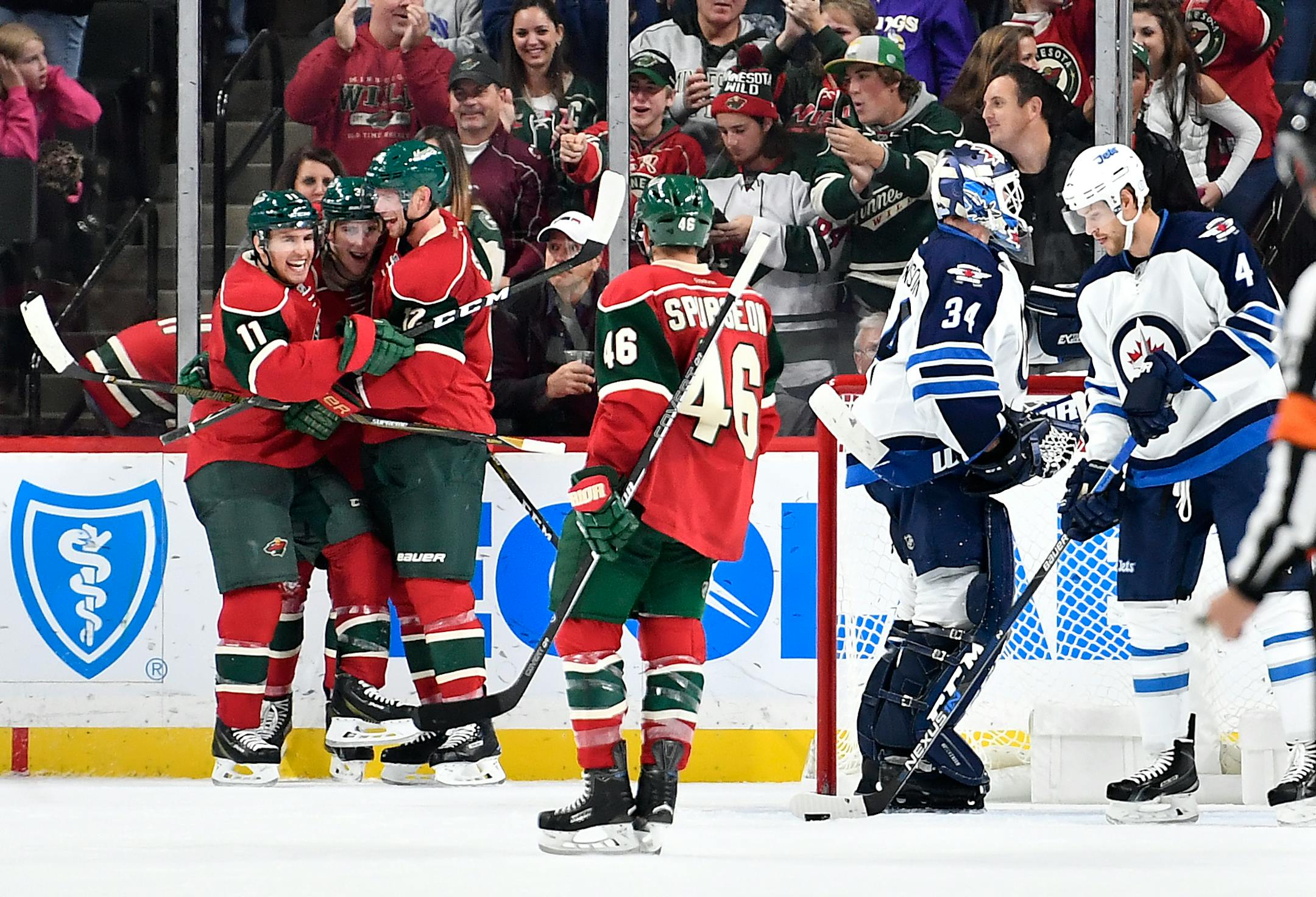 Minnesota Wild left wing Zach Parise (11), forward Charlie Coyle (3) and center Eric Staal (12) celebrate a third period goal by Coyle to put the Wild up 5-1 over the Winnipeg Jets.