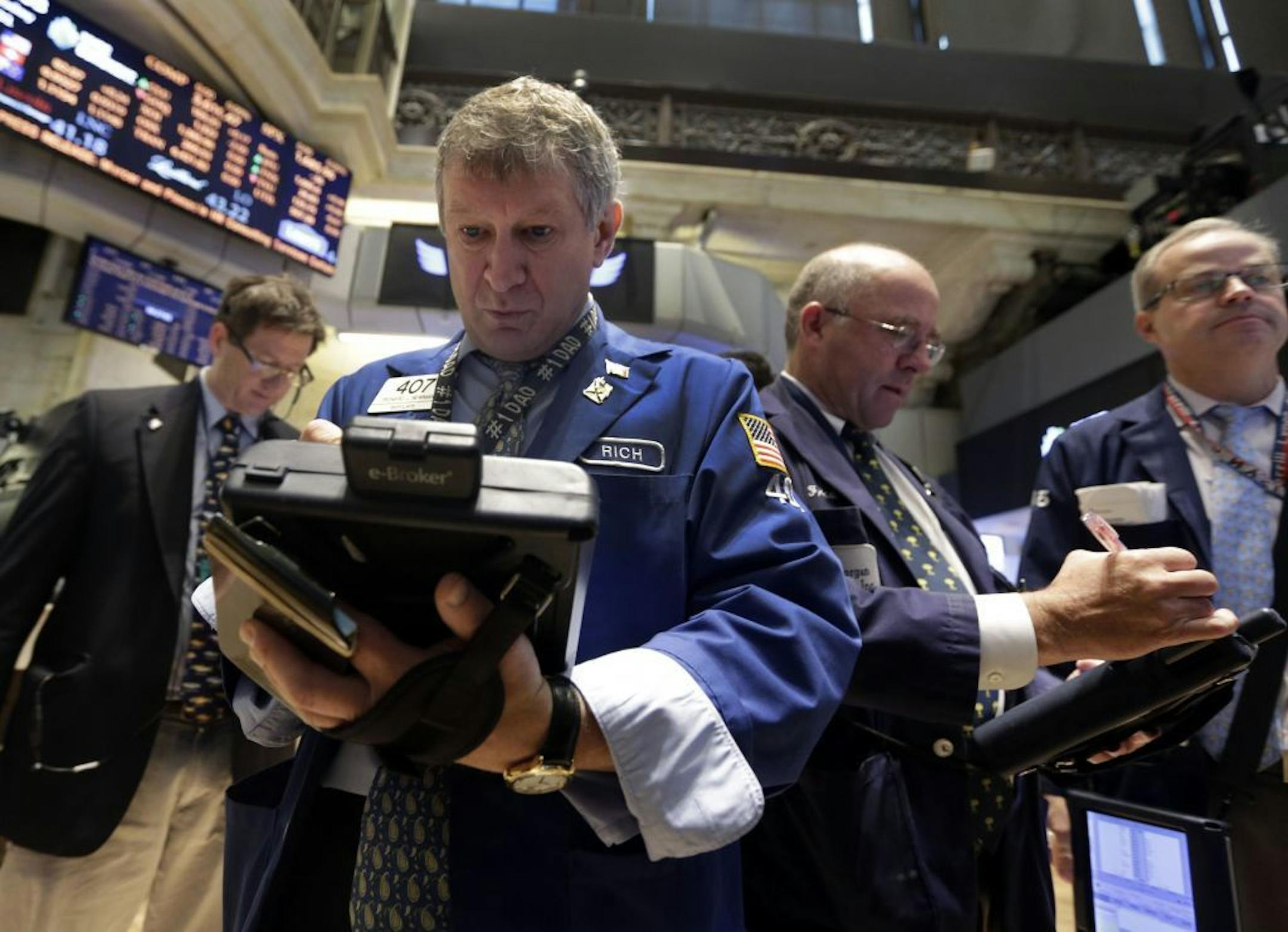 Richard Newman, second left, works with fellow traders on the floor of the New York Stock Exchange Wednesday, July 31, 2013. Steady growth in the U.S. economy and higher company earnings are pushing the stock market higher in early trading.
