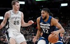 The Timberwolves' Karl-Anthony Towns drives against San Antonio Spurs' Jakob Poeltl during the first half
