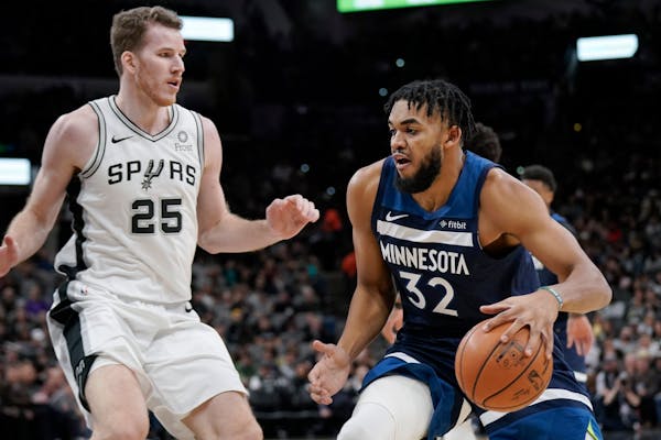 The Timberwolves' Karl-Anthony Towns drives against San Antonio Spurs' Jakob Poeltl during the first half