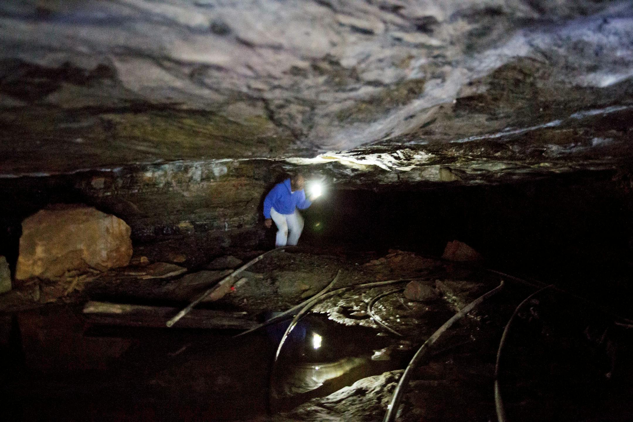 In this Oct. 19, 2014 photo, In this Oct. 19, 2014 photo, unemployed coal miner Steven Fields, 49, walks through an abandoned coal mine near where he grew up in Verda, Ky. Fields used to play in the abandoned mine as a child before following in his father's footsteps to become a miner himself. "I'm a coal miner, it's in my DNA," said Fields who was laid off from his last mining job five years ago and plans to leave his family behind to look for work in Alabama. "There just ain't nothing for me t