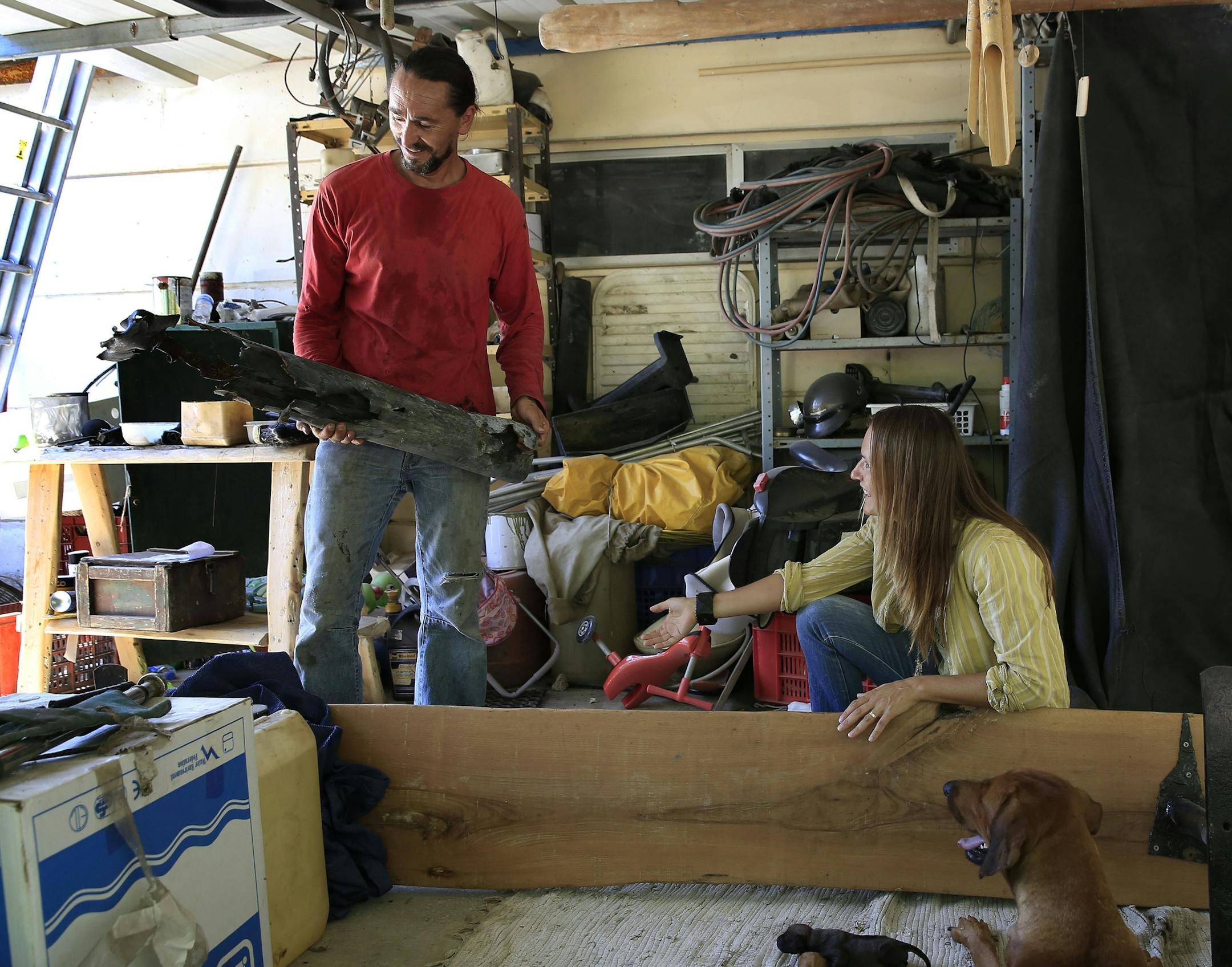 Avi Panzer, standing next to his wife Lucy, shows the remain of a rocket that they believe was fired by Palestinian militants to an area in Netiv Haasara, where they live near the Israel Gaza border on Wednesday, Aug. 6, 2014. They don't know when it was fired. Avi and Lucy Panzer didn't leave Netiv Haasara, an agricultural community that sits just north of the concrete wall that separates Israel from Gaza, during a war between Israel and Hamas in the Gaza Strip. With a cease-fire taking hold, r