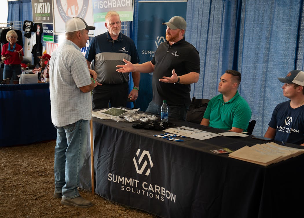 Scott O’Konek, project manager for Summit Carbon Solutions, center, talked to folks about his company’s carbon pipeline project Aug. 2 at Farmfest near Morgan, Minn.