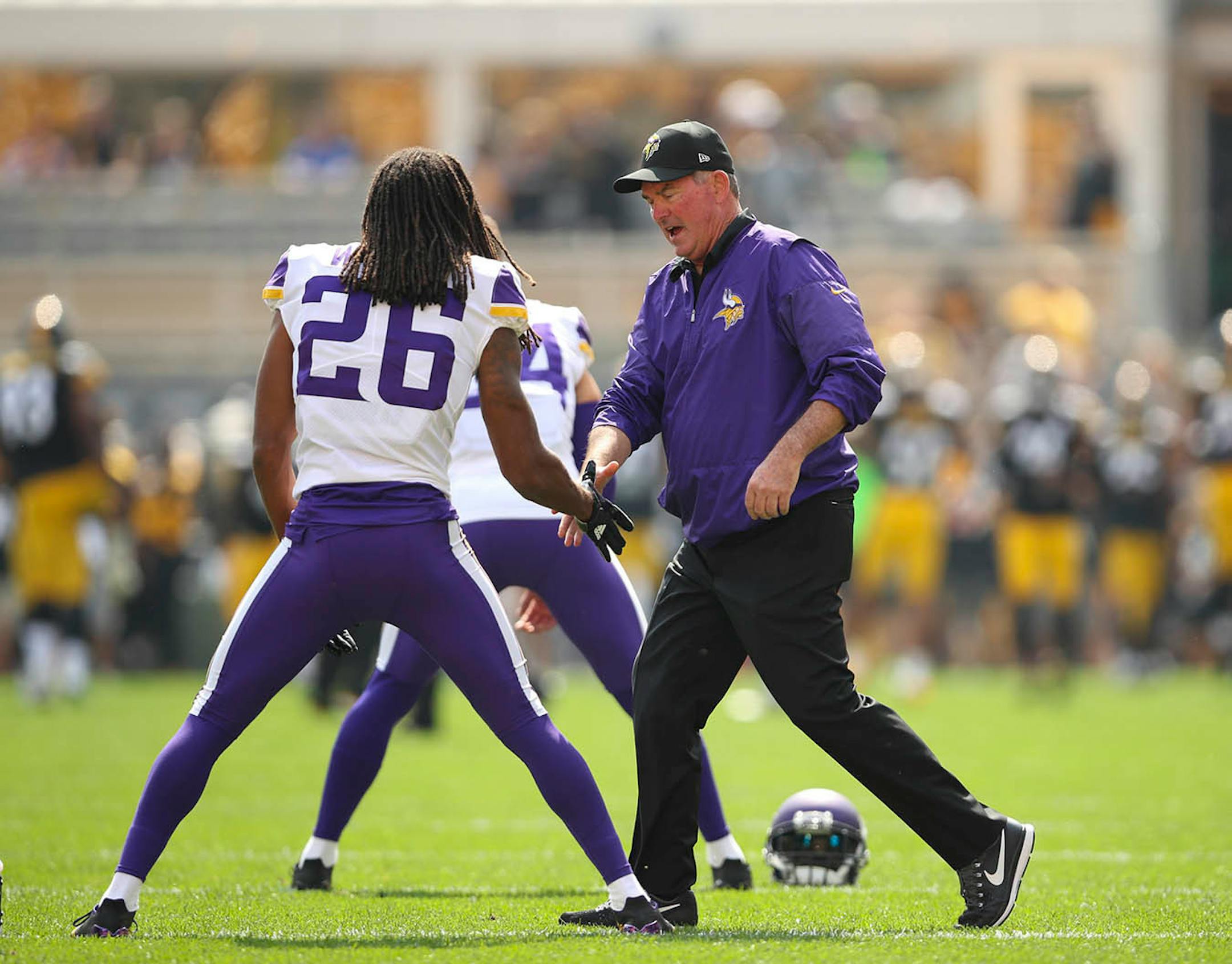 Minnesota Vikings head coach Mike Zimmer greeted players, including Minnesota Vikings cornerback Trae Waynes (26) as they stretched before Sunday's game against the Steelers.