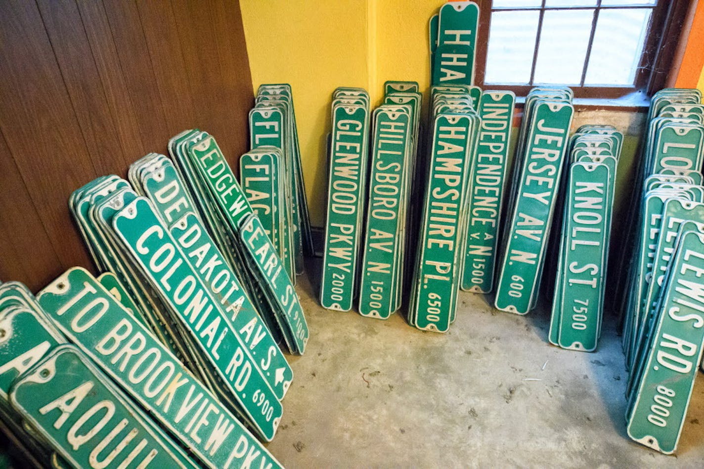 Stacks of old matte signs are for sale.