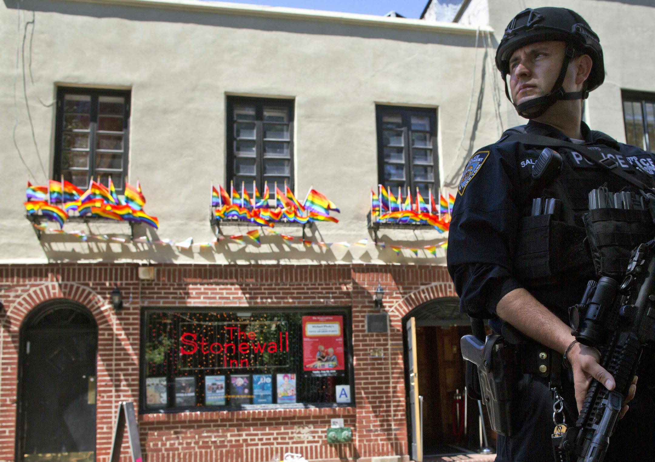 FILE - In this June 12, 2016 file photo, an armed police officer stands guard outside the Stonewall Inn in New York, after a gunman in Orlando, Fla., opened fire in a gay nightclub, spreading fear of more attacks. (AP Photo/Mary Altaffer, File)