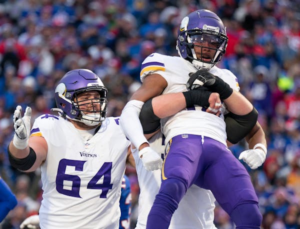 A Vikings offensive lineman lifted Minnesota Vikings wide receiver Justin Jefferson (18) up, after he got the ball down to the one yard line late in t