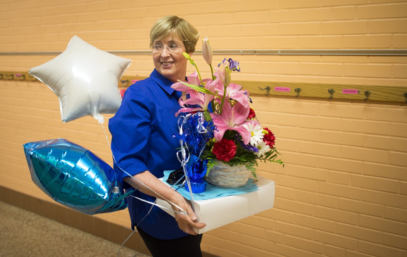 Kay Hawley walks to her office with gifts given to her after the final concert of her 42 years as a teacher. ] (Aaron Lavinsky | StarTribune) aaron.lavinsky@startribune.com Kay Hawley, a Hopkins music teacher, is retiring after 42 years. Recently, the district invited back some of her former students for a concert to give her a Mr. Holland's Opus type send off. The concert was held Tuesday, May 5, 2015 at Glen Lake Elementary in Minnetonka.