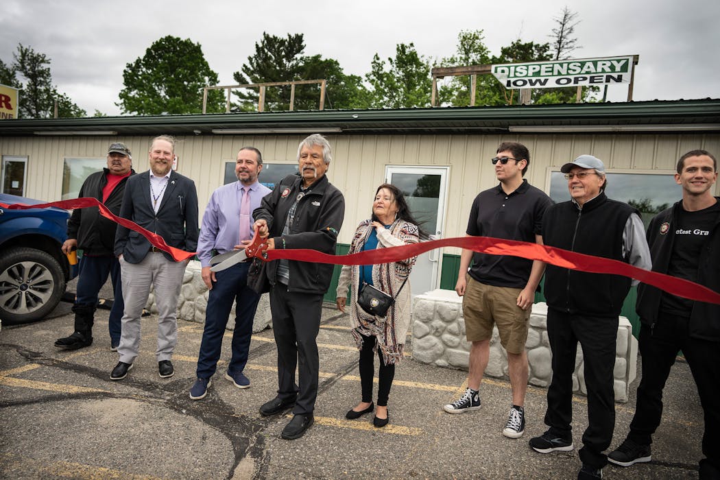 Leech Lake Band of Ojibwe Tribal chairman Faron Jackson, center, cuts the ribbon during the opening of the Sweetest Grass cannabis dispensary Thursday in Walker. 