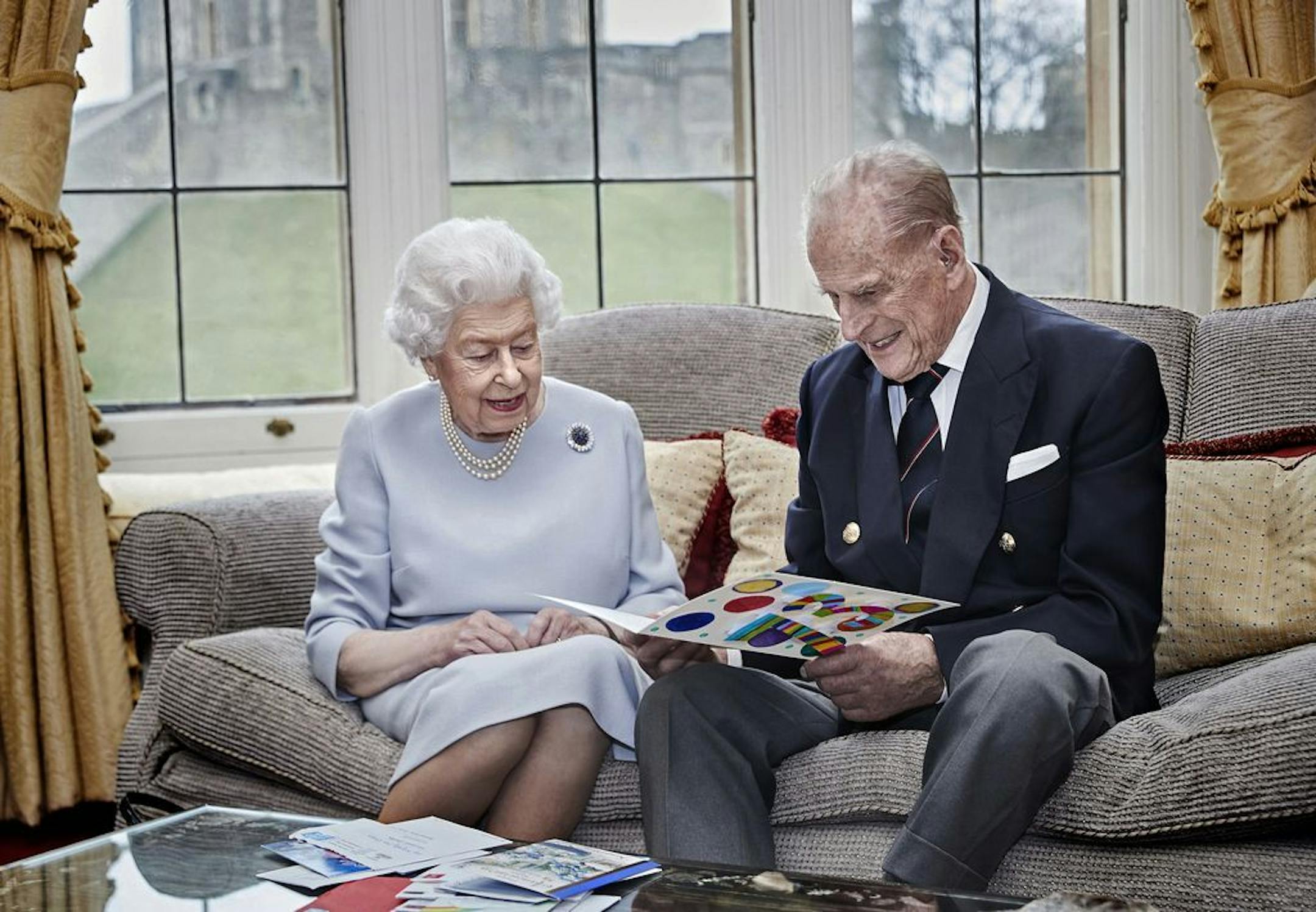 Britain's Queen Elizabeth II and Prince Philip, Duke of Edinburgh look at a homemade wedding anniversary card, given to them by their great-grandchildren Prince George, Princess Charlotte and Prince Louis, in the Oak Room at Windsor Castle, England, Nov. 17, 2020, ahead of their 73rd wedding anniversary. Elizabeth married Philip on Nov. 20, 1947, at Westminster Abbey in London.