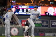 Los Angeles Dodgers designated hitter Shohei Ohtani heads home after celebrating his seventh inning solo homer with Dodgers third base coach Dino Ebel