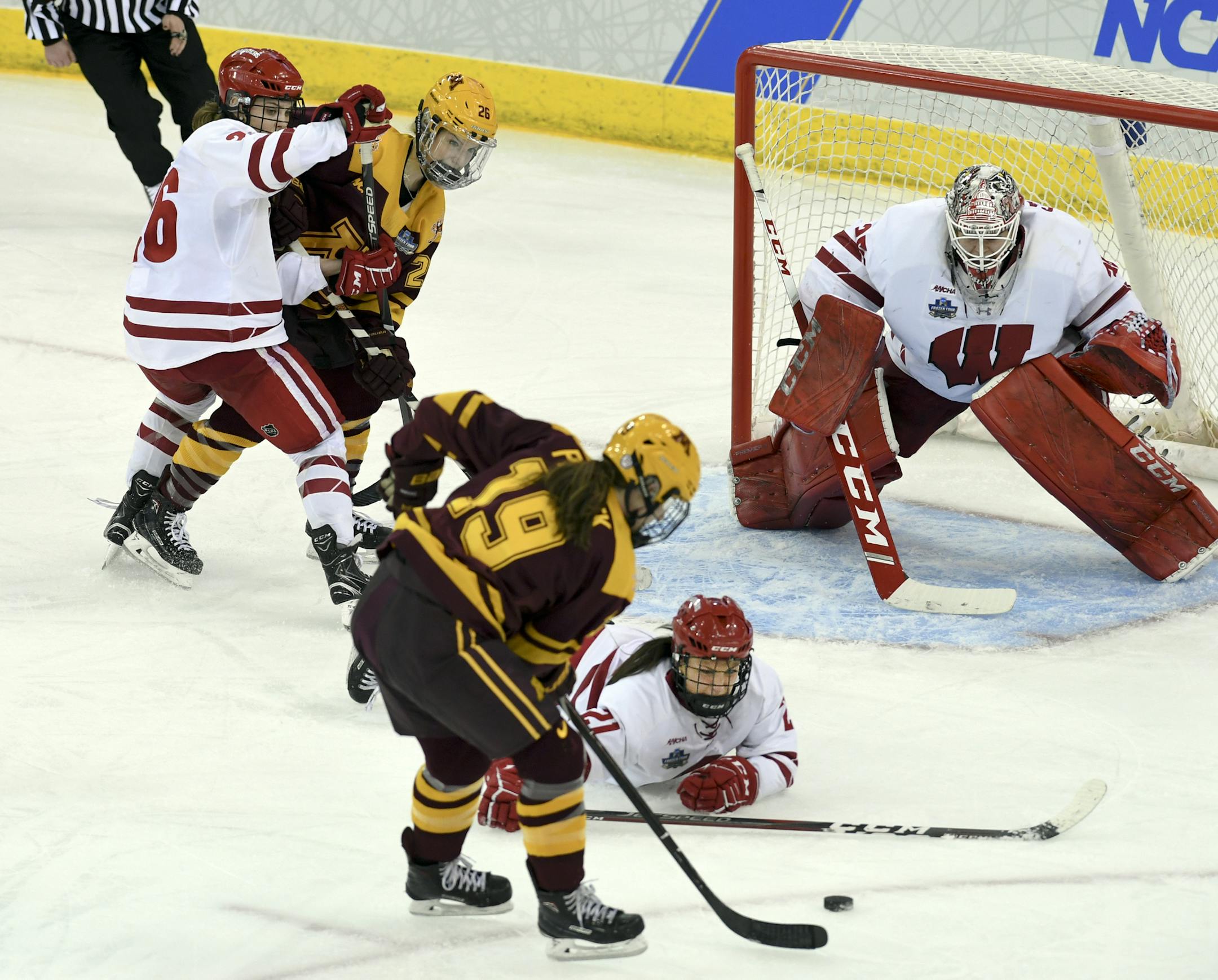 Minnesota's Kelly Pannek (19) sets up for a shot while defended by Wisconsin's Sophia Shaver (12) and Wisconsin goaltender Kristen Campbell (35) during the third period in the NCAA Division I women's Frozen Four hockey championship game, Sunday, March 24, 2019, in Hamden, Conn. (AP Photo/Stephen Dunn)