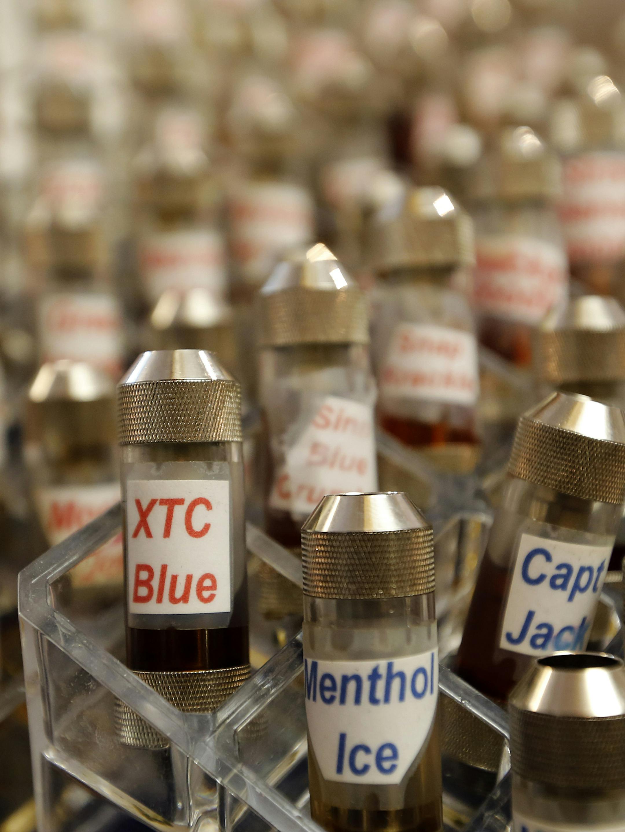 FILE - This Dec. 4, 2013 file photo, shows vials of flavored liquid at Vapeology LA, a store selling electronic cigarettes and related items, at John Hartigan's store in Los Angeles. The Los Angeles City Council voted 14-0 to approve an ordinance to ban e-cigarette use, or "vaping" at public places where tobacco smoking is restricted. (AP Photo/Reed Saxon, File)
