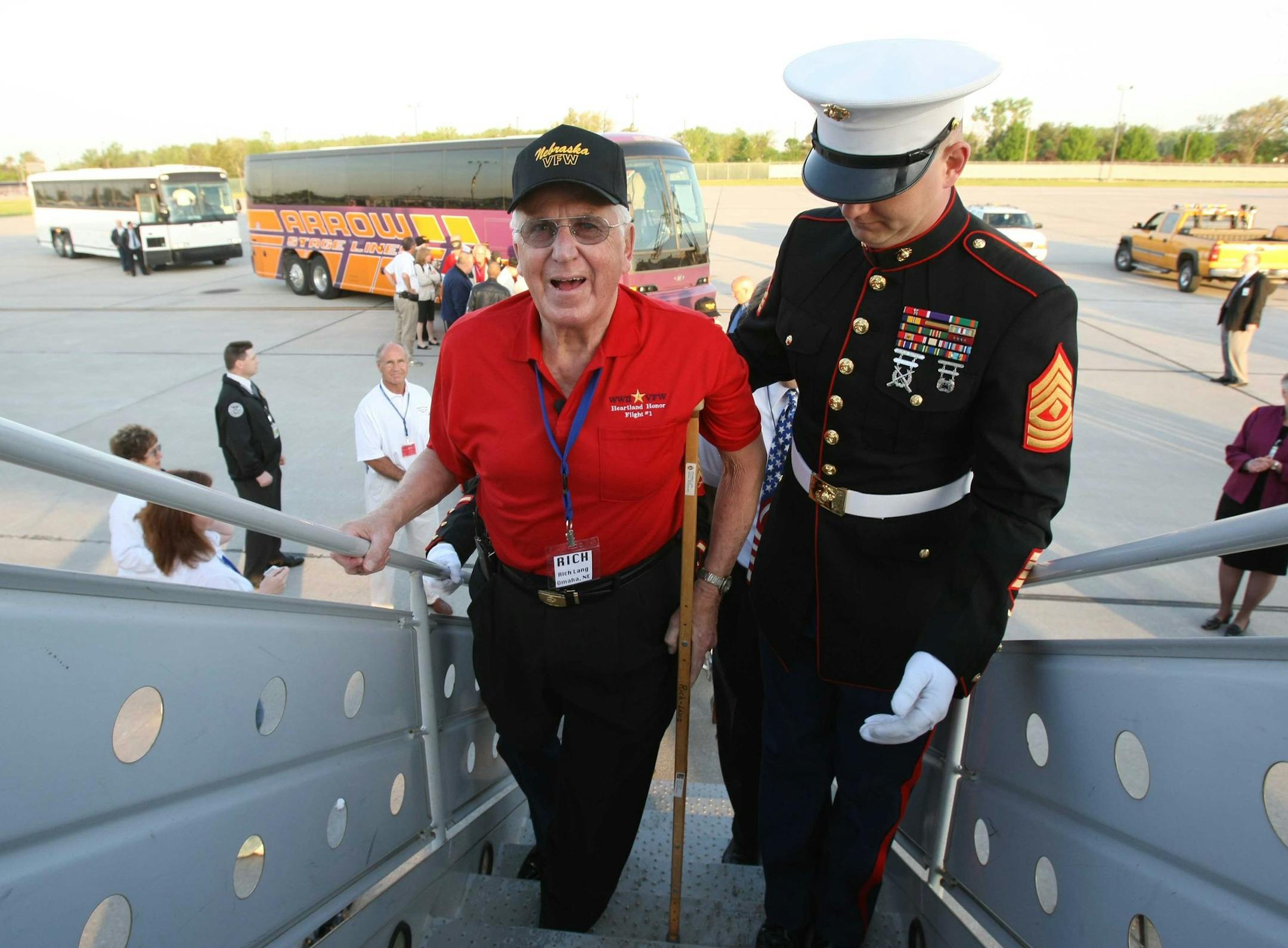 In this May 21, 2008 photo, Richard Lang, whose right leg was amputated, is escorted up the flight stairs by Marine First Sgt. Wade Jensen at Eppley Airfield in Omaha, Neb. during an Honor Flight to Washington for World War II veterans. Bill Williams, whose company sponsored the event, advised him there was a steep set of plane stairs. "I made my big mistake," Williams recalls. "I said, 'We will carry you.' ... He said, 'Listen pal, I haven't been carried since Guam.'" Lang said he'd sit on his