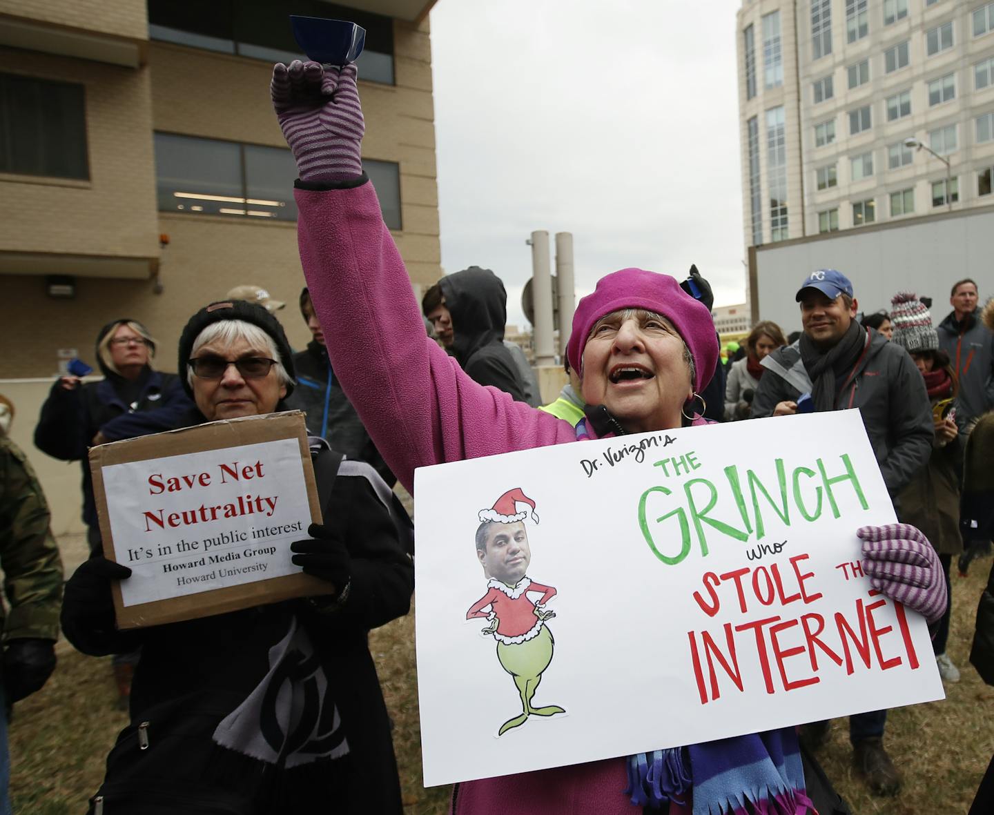 Diane Tepfer holds a sign with an image of Federal Communications Commission (FCC) Chairman Ajit Pai as the "Grinch who Stole the Internet" as she protests near the FCC, in Washington, Thursday, Dec. 14, 2017. The FCC voted to eliminate net-neutrality protections for the internet. (AP Photo/Carolyn Kaster)