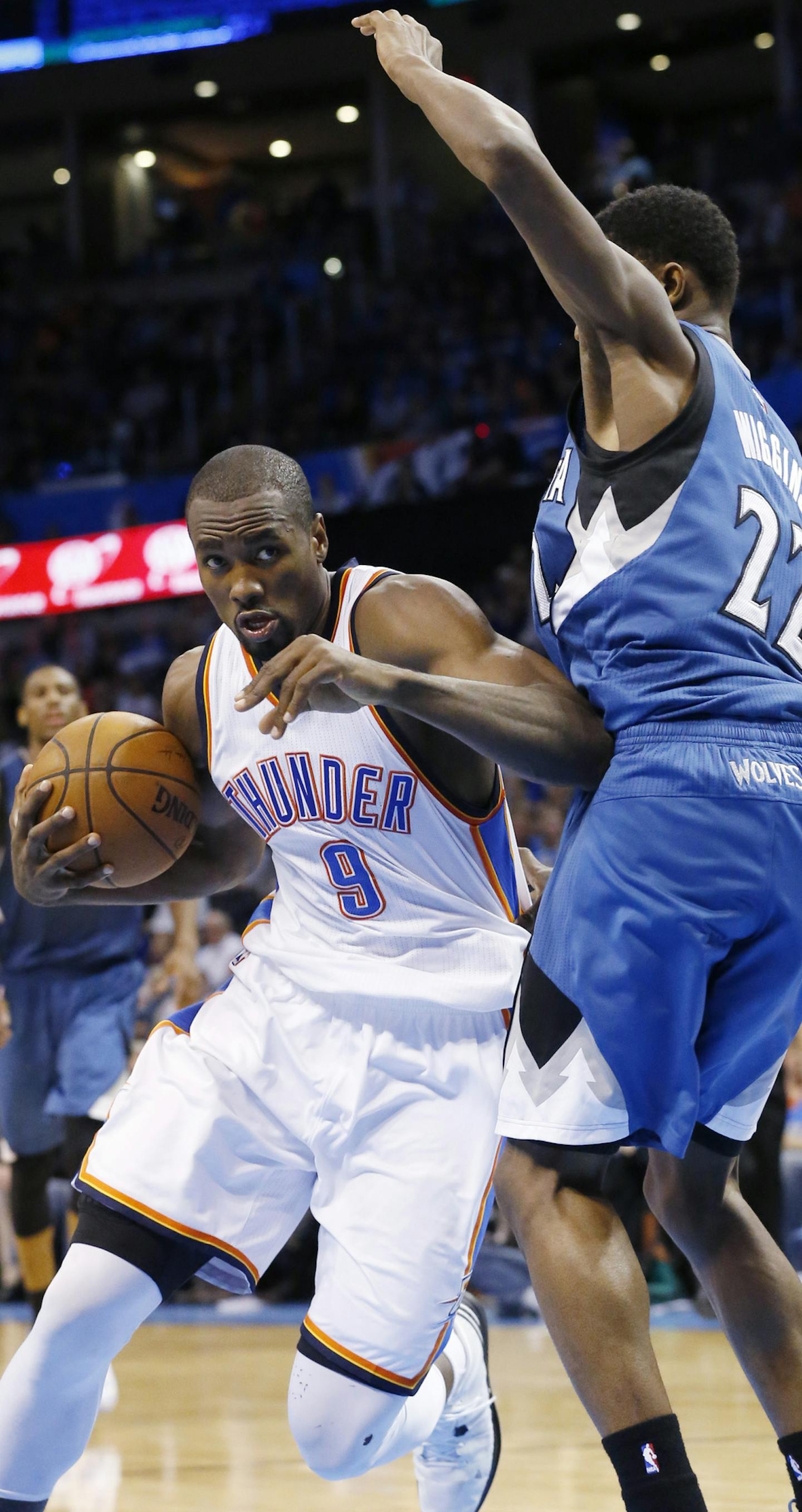 Oklahoma City Thunder forward Serge Ibaka (9) drives around Minnesota Timberwolves forward Andrew Wiggins (22) in the fourth quarter of an NBA basketball game in Oklahoma City, Monday, Jan. 26, 2015. Oklahoma City won 92-84. (AP Photo/Sue Ogrocki)