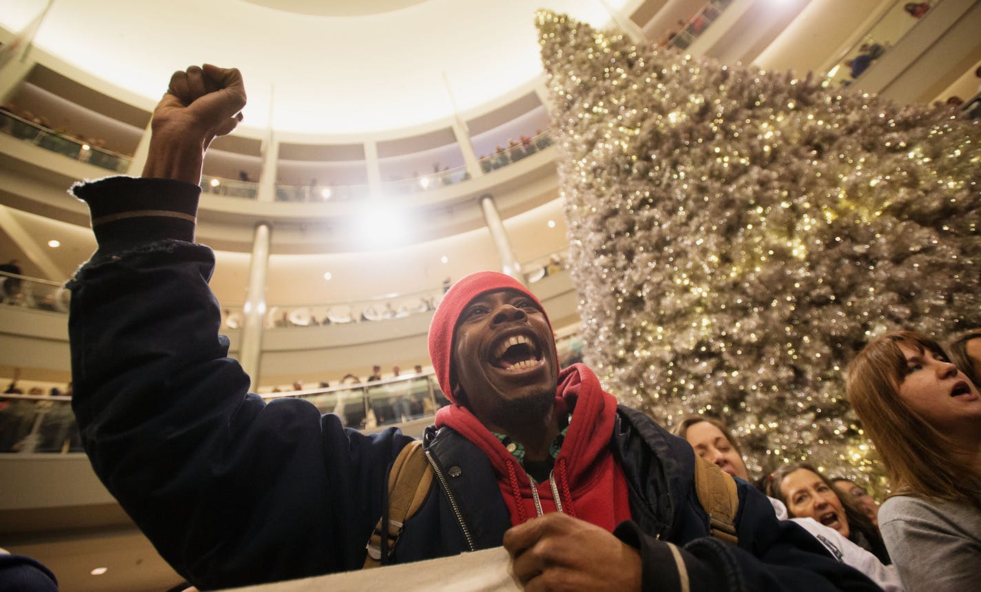 A year ago: In this Dec. 20, 2014, photo, Janerio Taylor, of Minneapolis, chants with other demonstrators during a Black Lives Matter protest at the Mall of America rotunda in Bloomington, Minn.