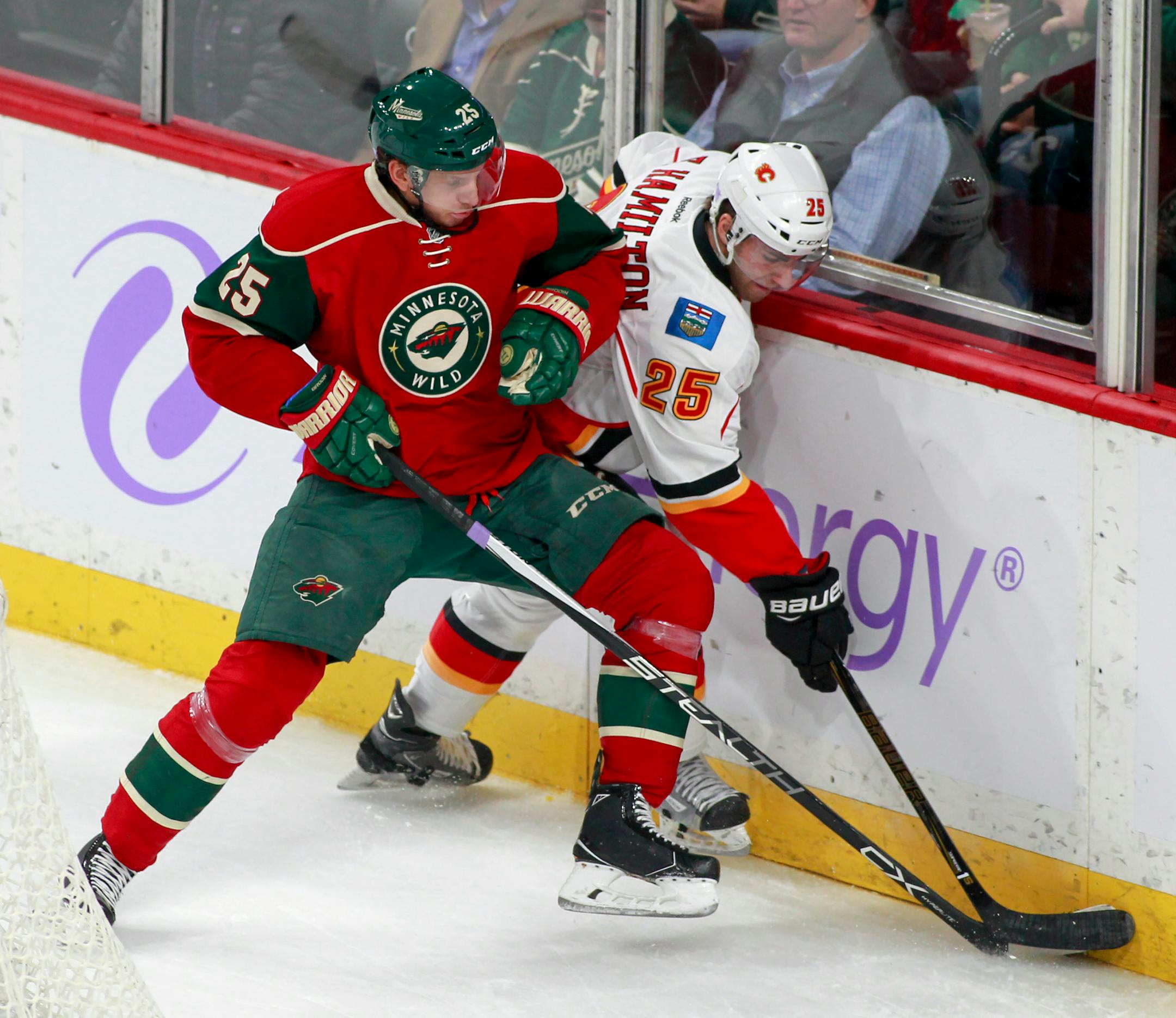 Minnesota Wild defenseman Jonas Brodin (25),, of Sweden, and Calgary Flames center Freddie Hamilton (25) battle along the boards during the first period of an NHL hockey game, Tuesday, Nov. 15, 2016, in St. Paul, Minn. (AP Photo/Paul Battaglia)