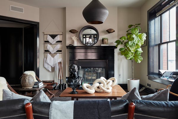 A fireplace painted a glossy black helps add texture and color to this living space. 