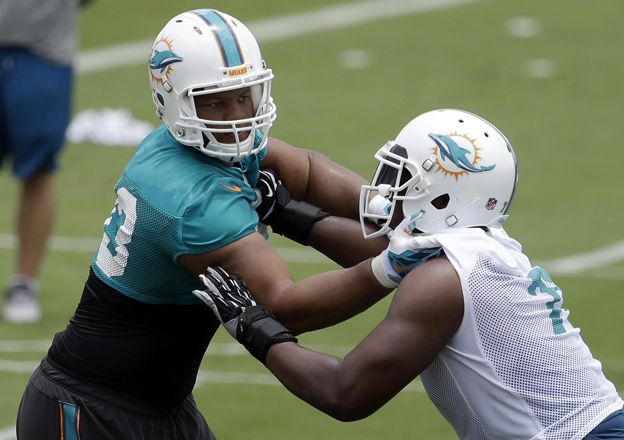 Miami Dolphins defensive tackle Ndamukong Suh, left, works on a drill with Ja'Wuan James (70) during an NFL football organized team activity, Monday, June 8, 2015, in Davie, Fla. (AP Photo/Lynne Sladky) ORG XMIT: FLLS102