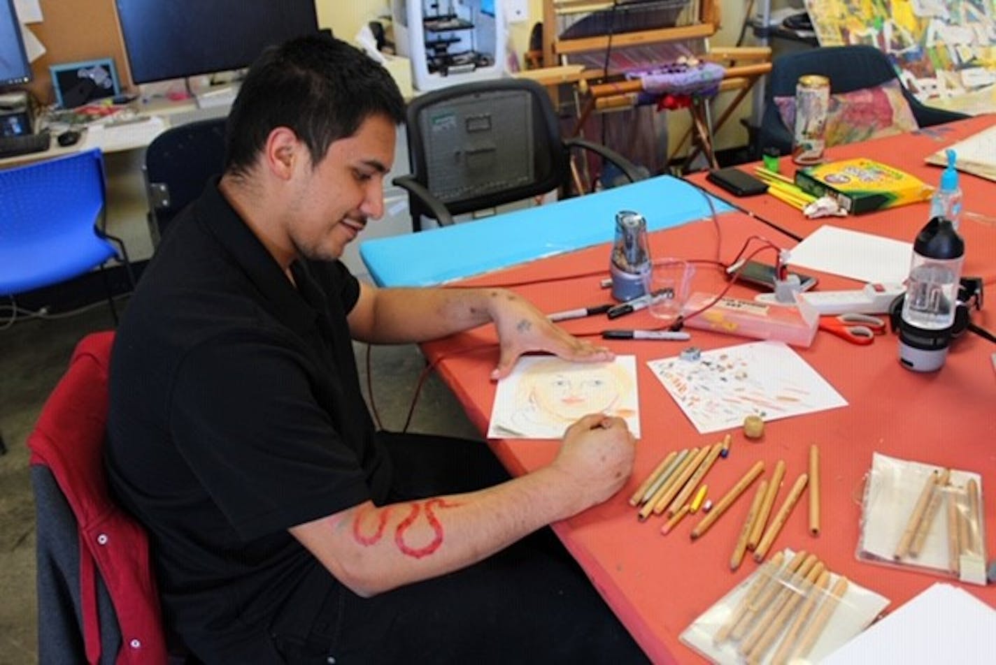 Artist Juan Mendoza works in the studio at Interact in St. Paul. Interact, a visual and performing arts center for people with disabilities, is working to keep its artists connected and its staff paid during the pandemic.