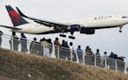 People watched a Delta Air Lines jet approach Tokyo's Narita International Airport.