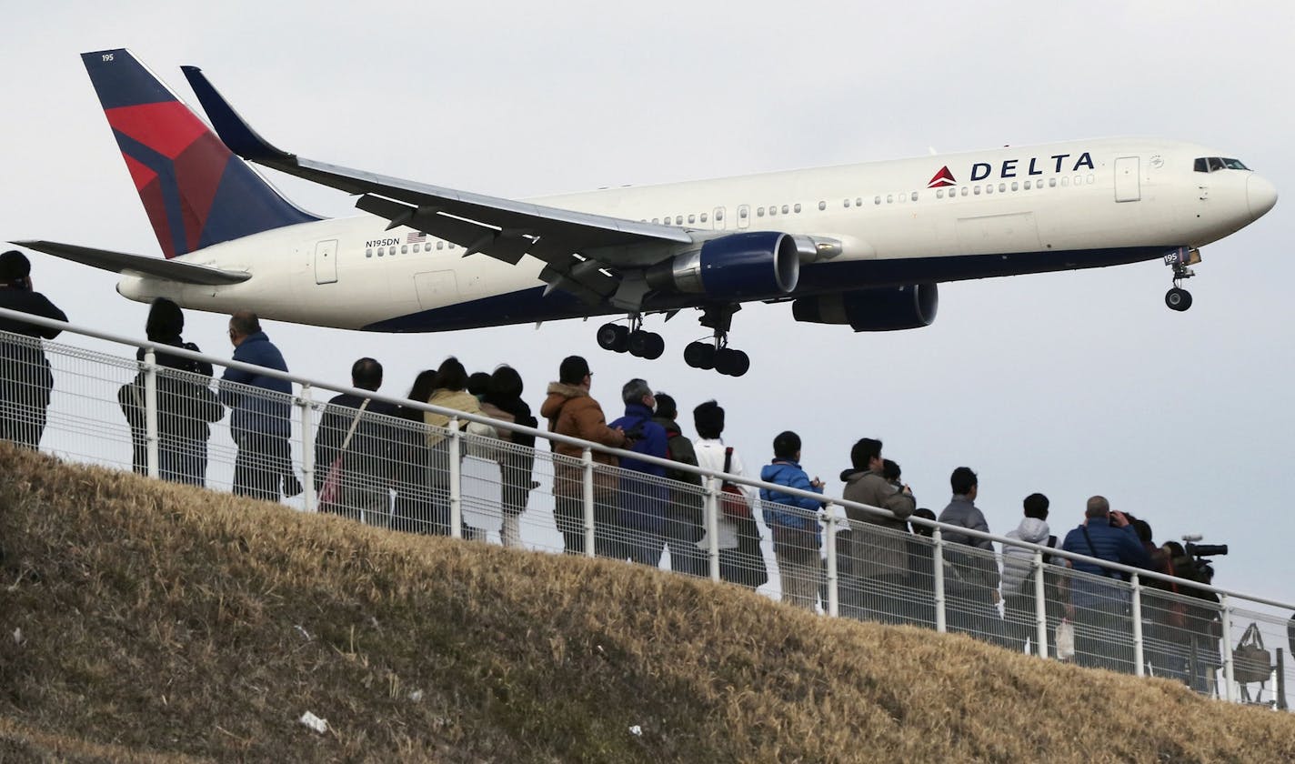 People watched a Delta Air Lines jet approach Tokyo's Narita International Airport.